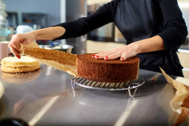 Woman decorating a cake with whipped cream
