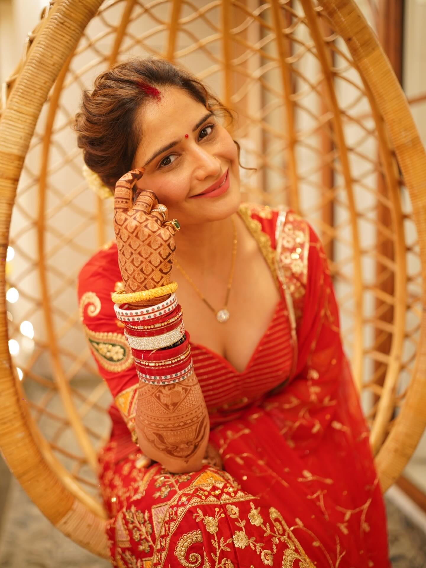 Arti Singh smiling sweetly in a traditional red bridal look