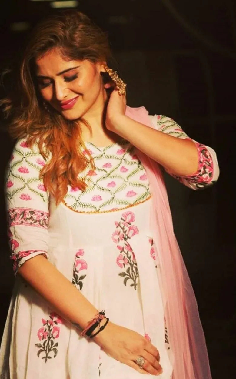 Arti Singh is looking down at a pink embroidered kurti image