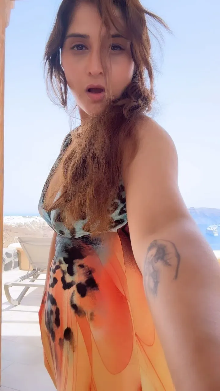 Arti Singh in a flowy beach dress with wind in her hair