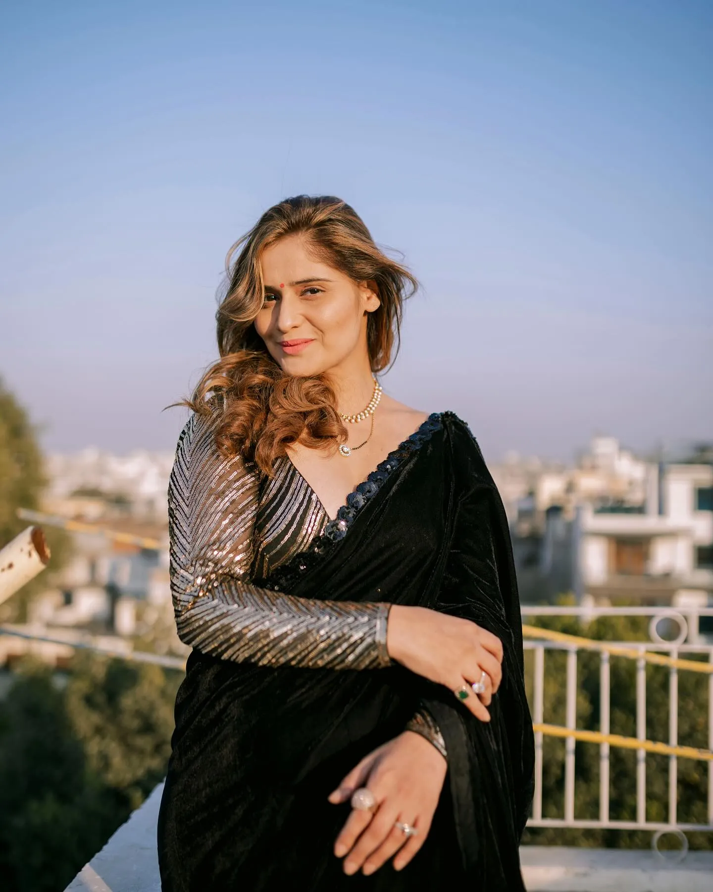 Arti Singh standing confidently in a black stylish outfit