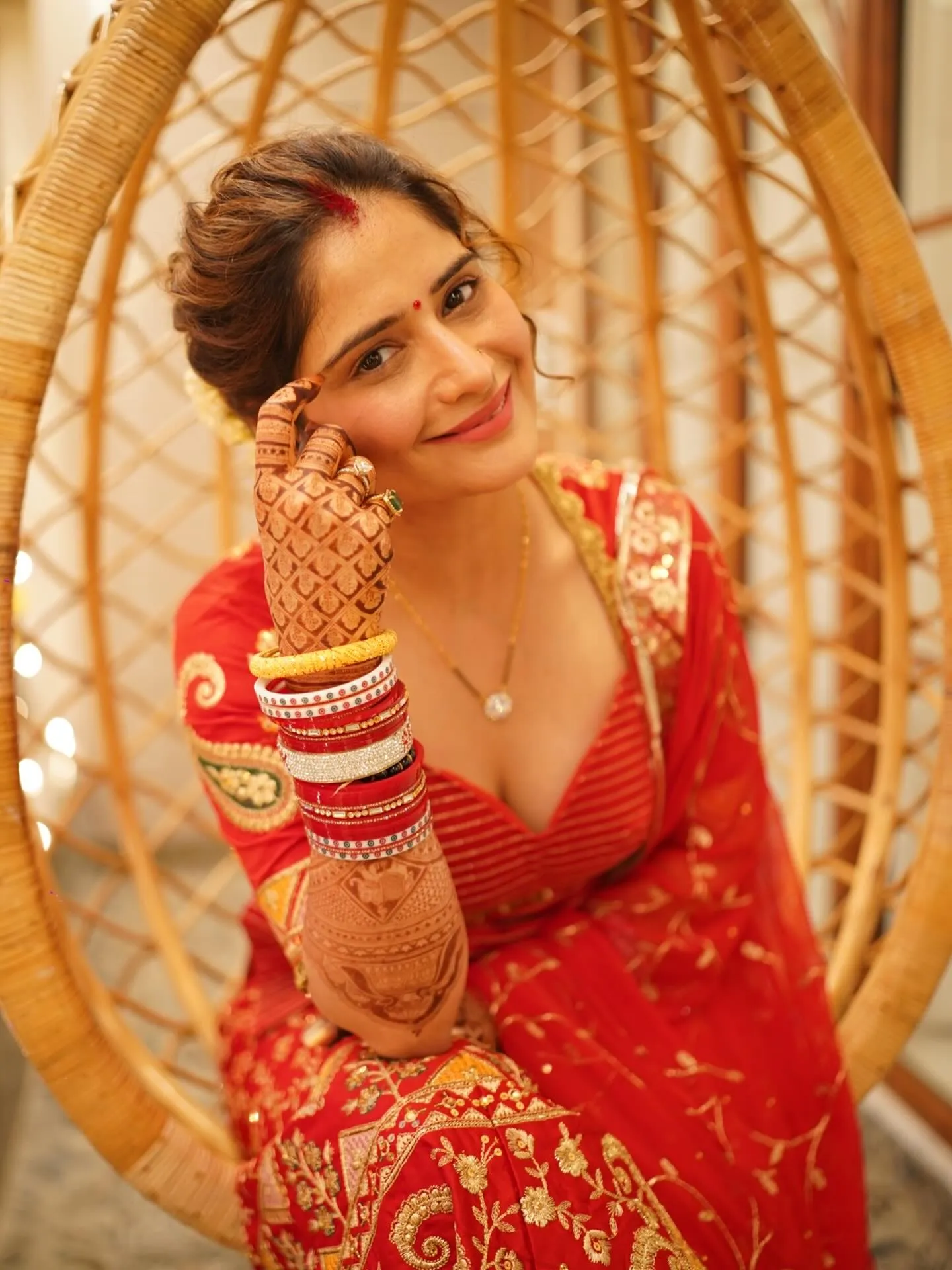 Arti Singh smiling sweetly in a traditional red bridal look