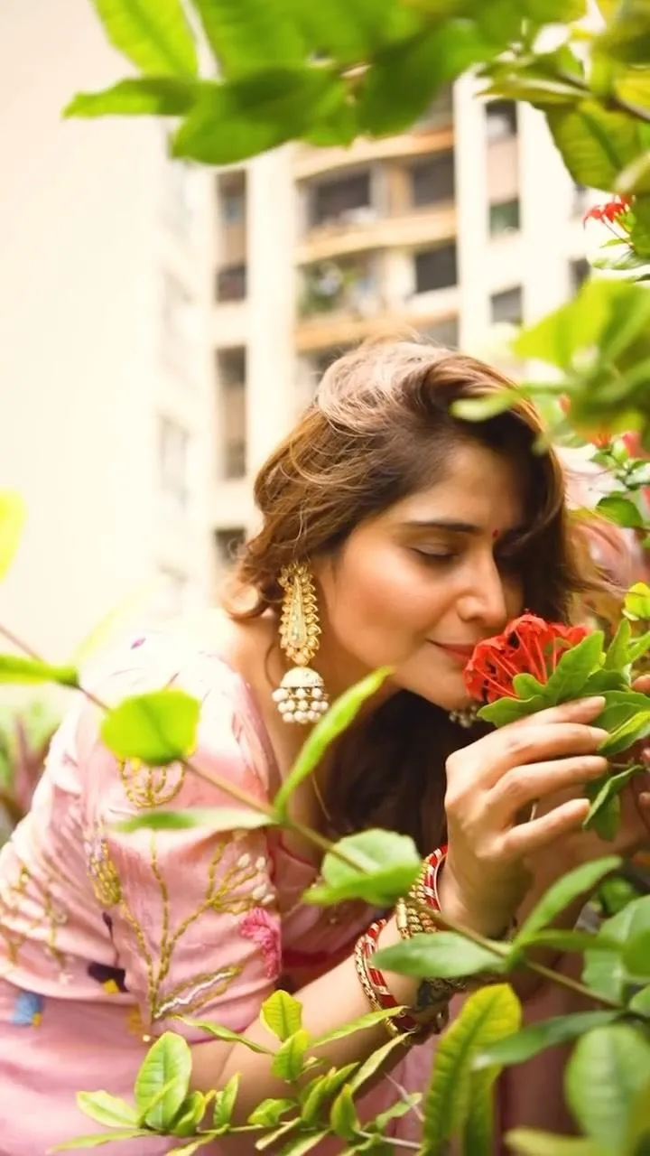 Arti Singh admires flowers in a soft pink striped kurta