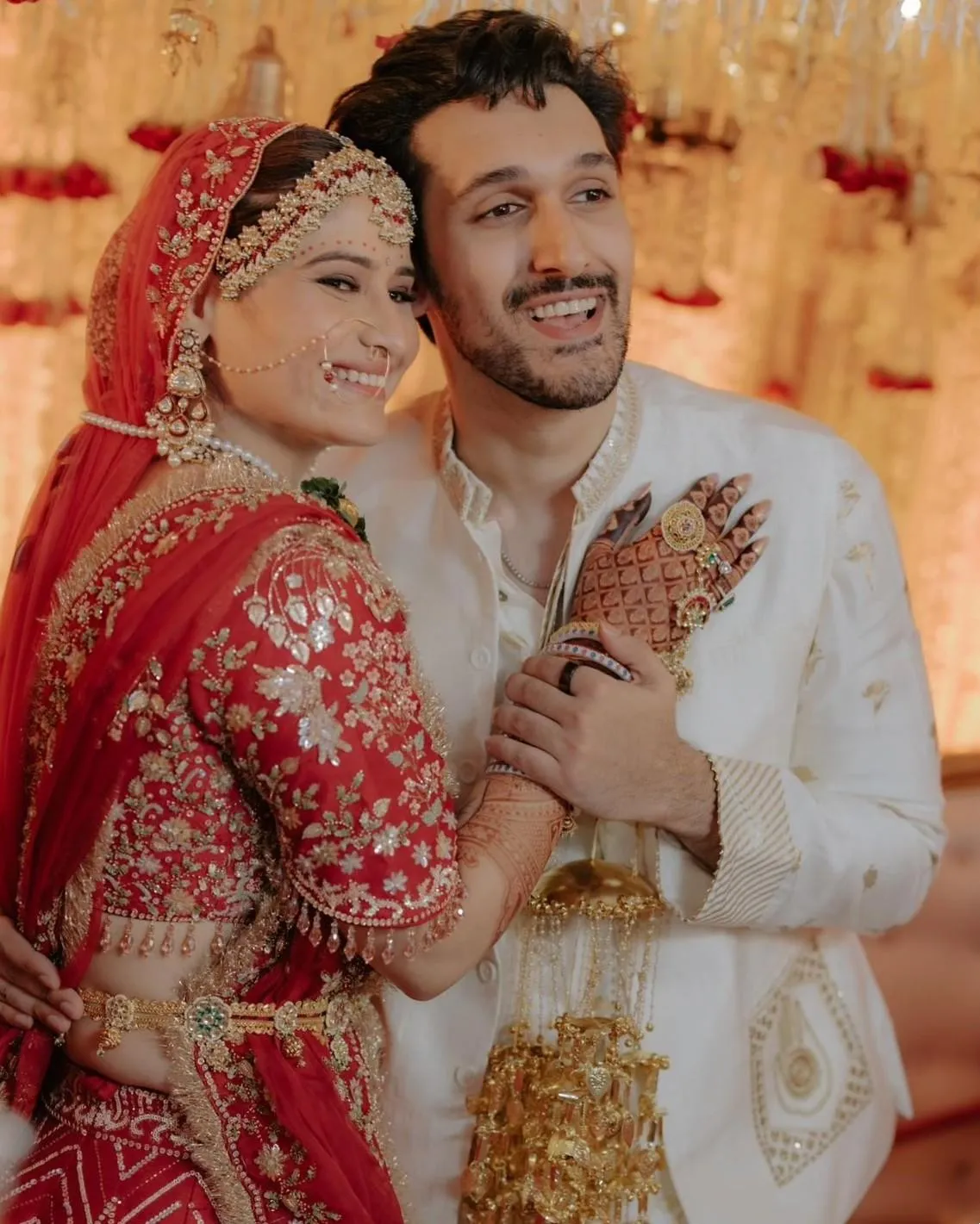 Arti Singh and her husband pose joyfully in wedding outfits