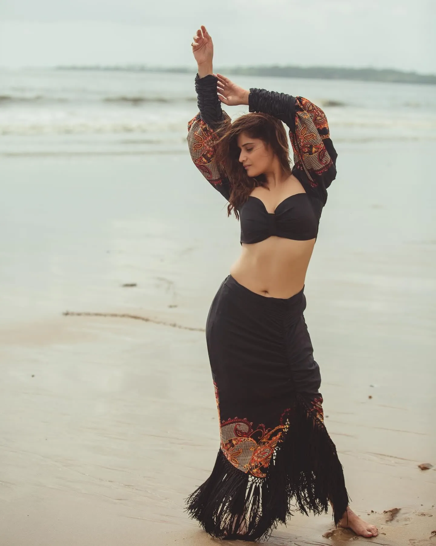 Arti Singh dances playfully on the beach in a black outfit