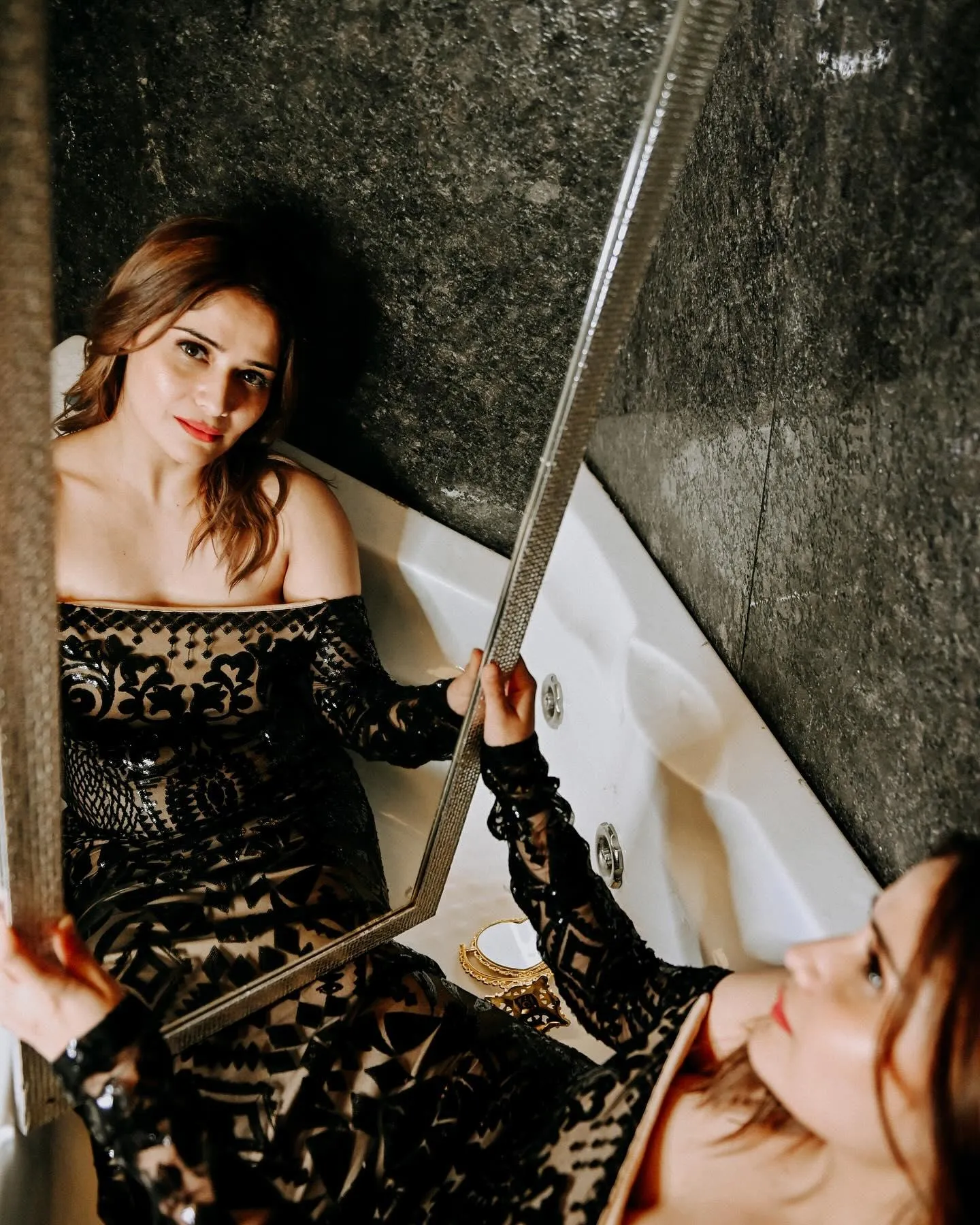 Arti Singh holds a mirror in a royal black traditional outfit