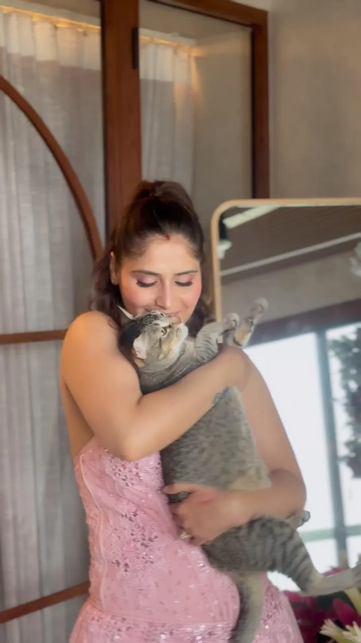 Arti Singh in a cozy moment in a pink dress with her pet cat