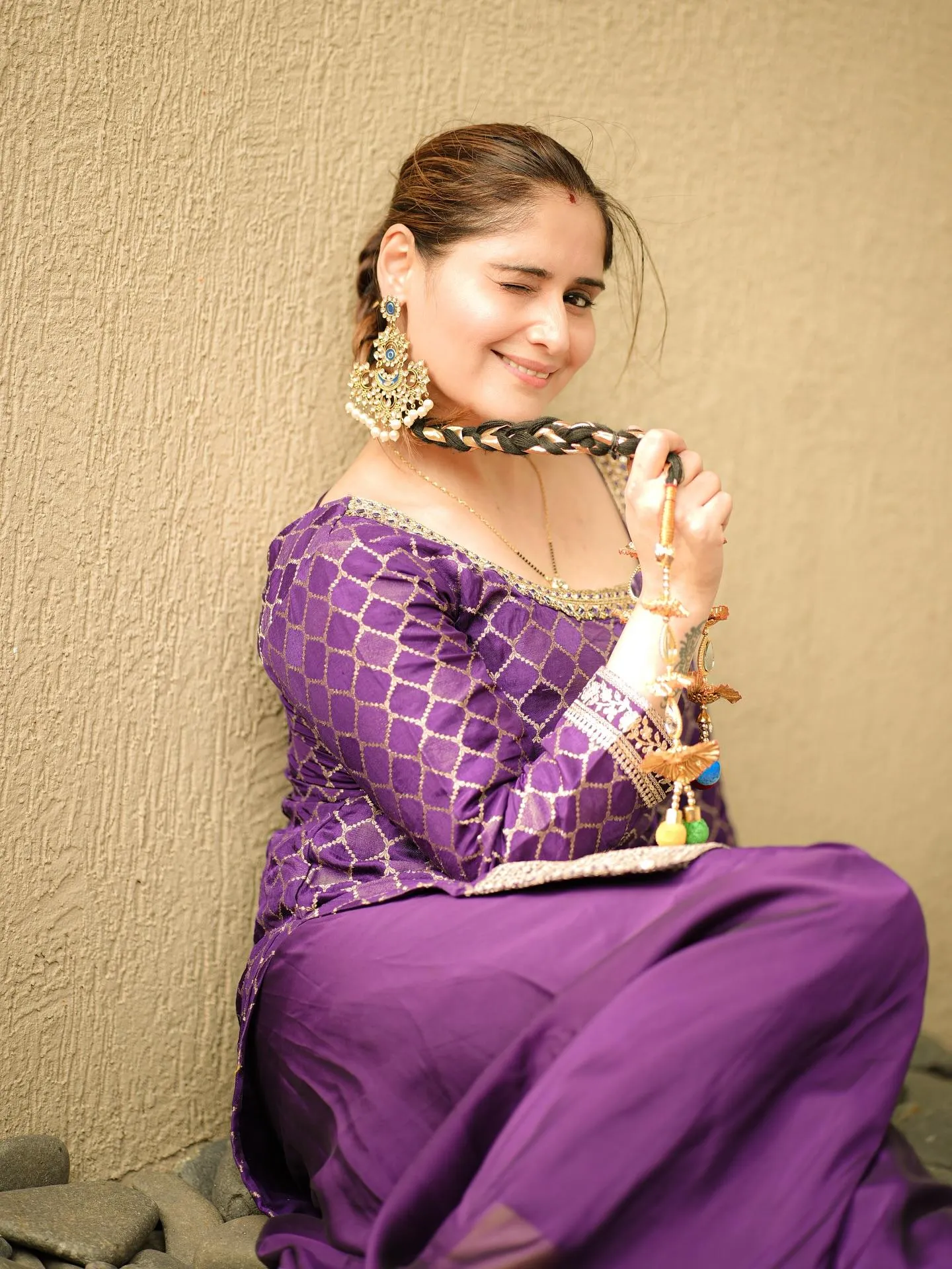 Arti Singh in a purple saree poses with a bright expression