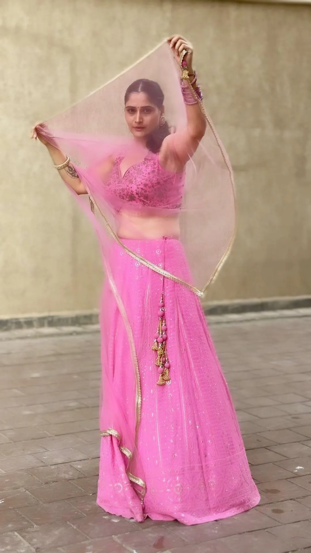 Arti Singh in a vibrant pink ethnic outfit with hand raised