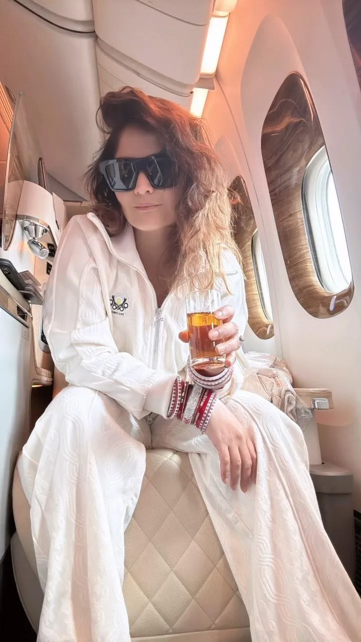 Arti Singh in a white outfit sitting on a plane wallpaper