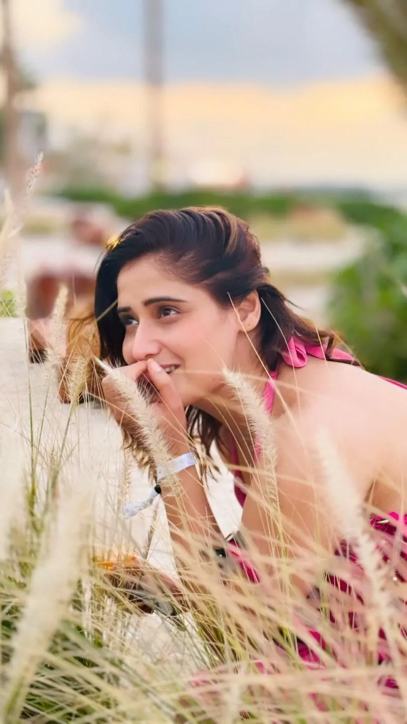 Arti Singh laughs joyfully in a pink boho outfit outdoors