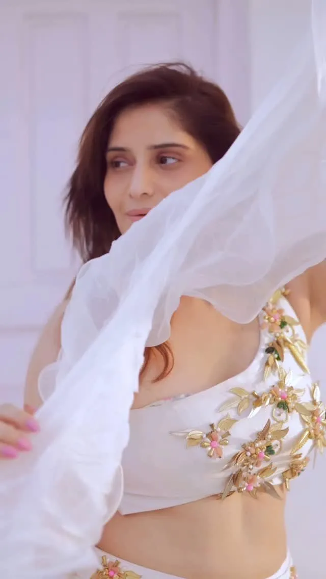 Arti Singh peeks through a sheer white dupatta with grace