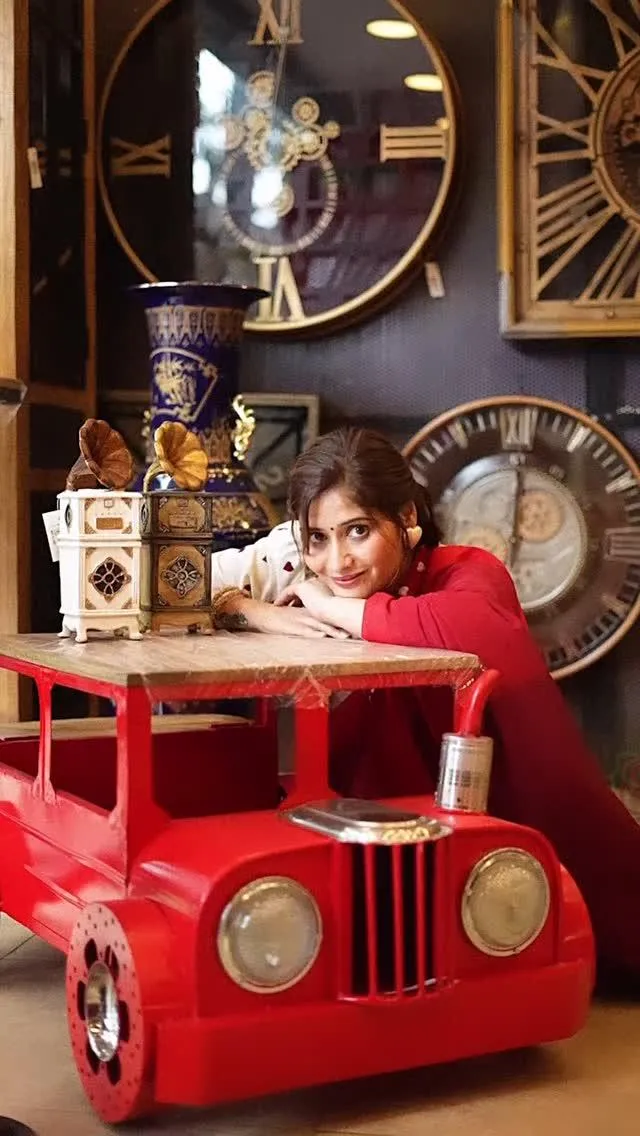 Arti Singh plays with a red toy car in a whimsical setup