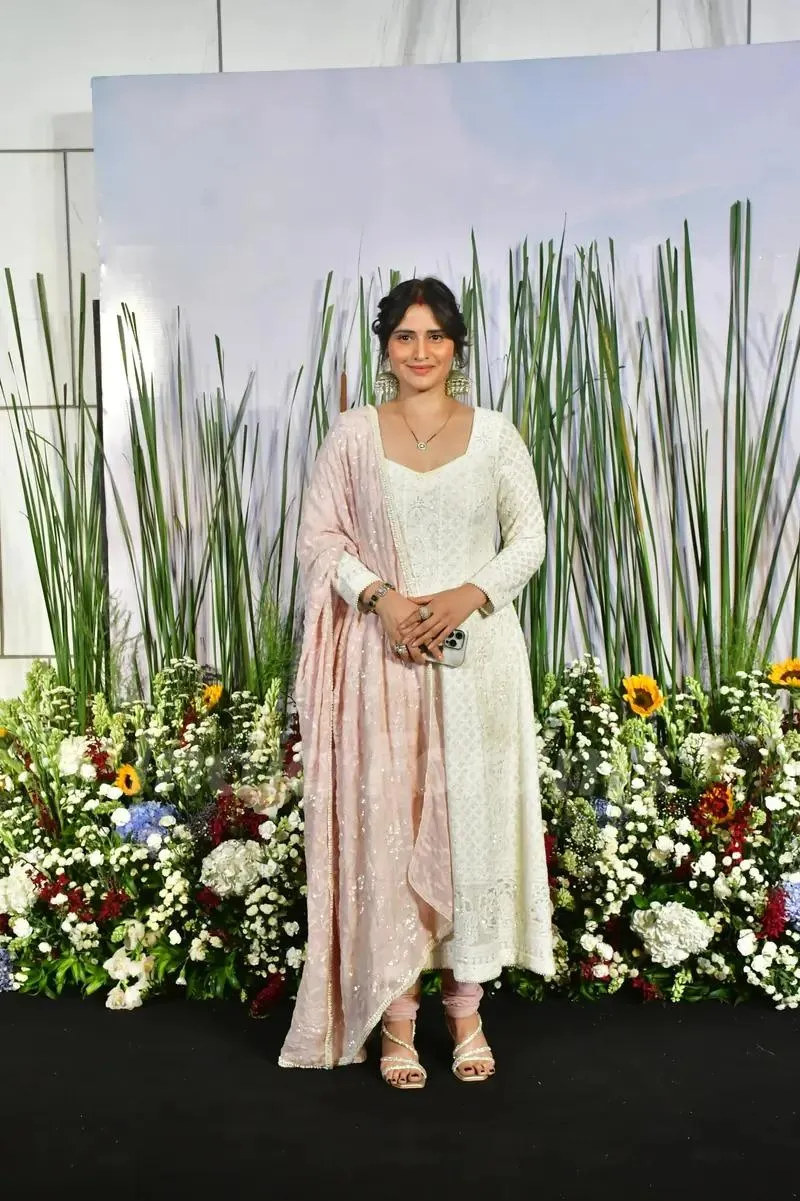 Arti Singh poses in a white dress at a floral themed event