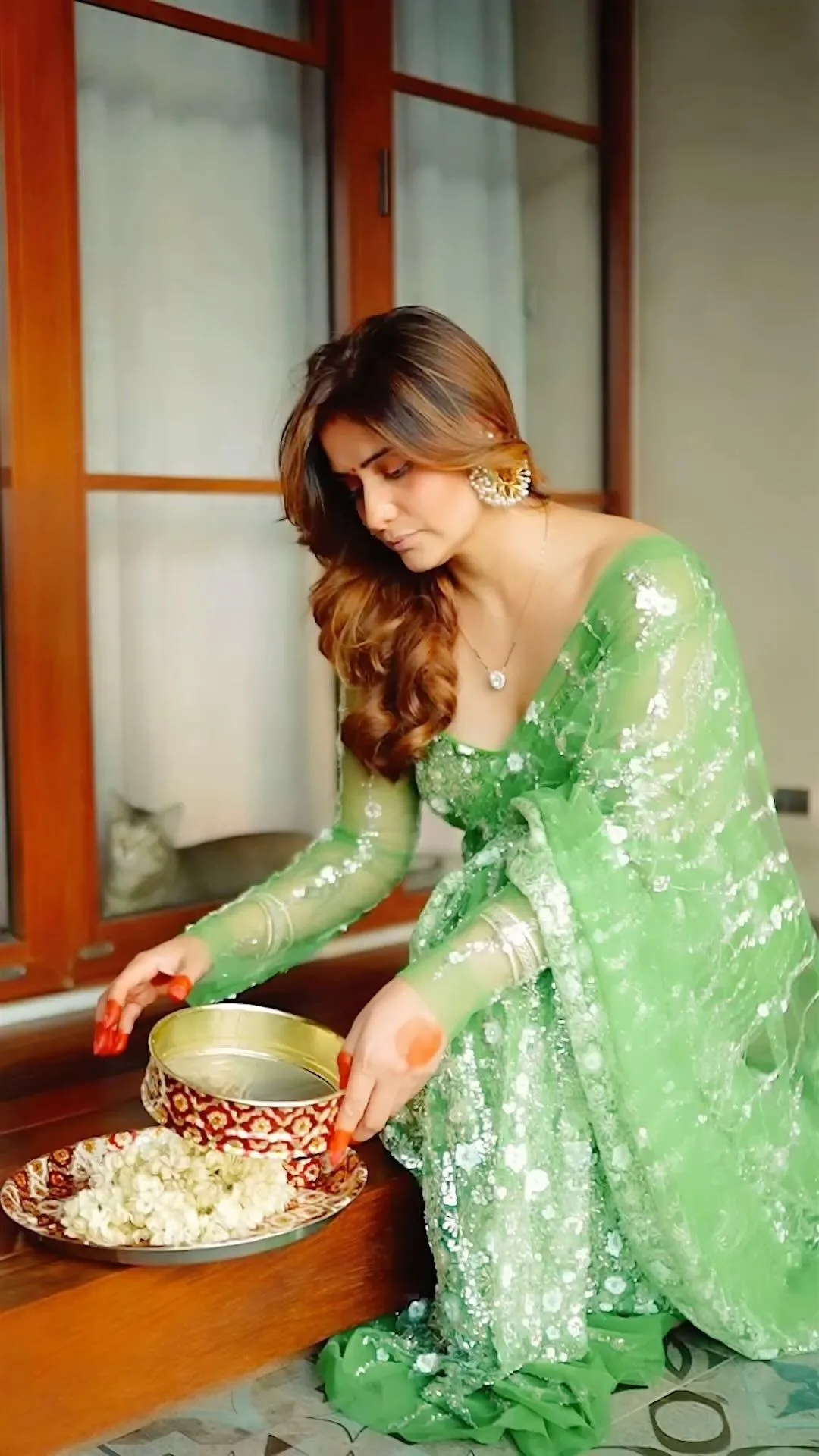 Arti Singh prepares a ritual thali in a bright green outfit