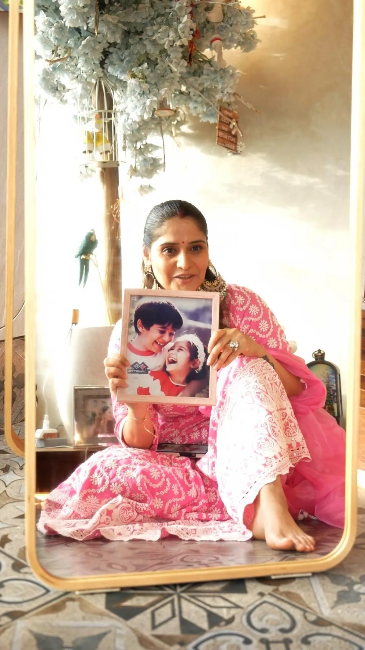 Arti Singh sits on floor in pink ethnic outfit holding book