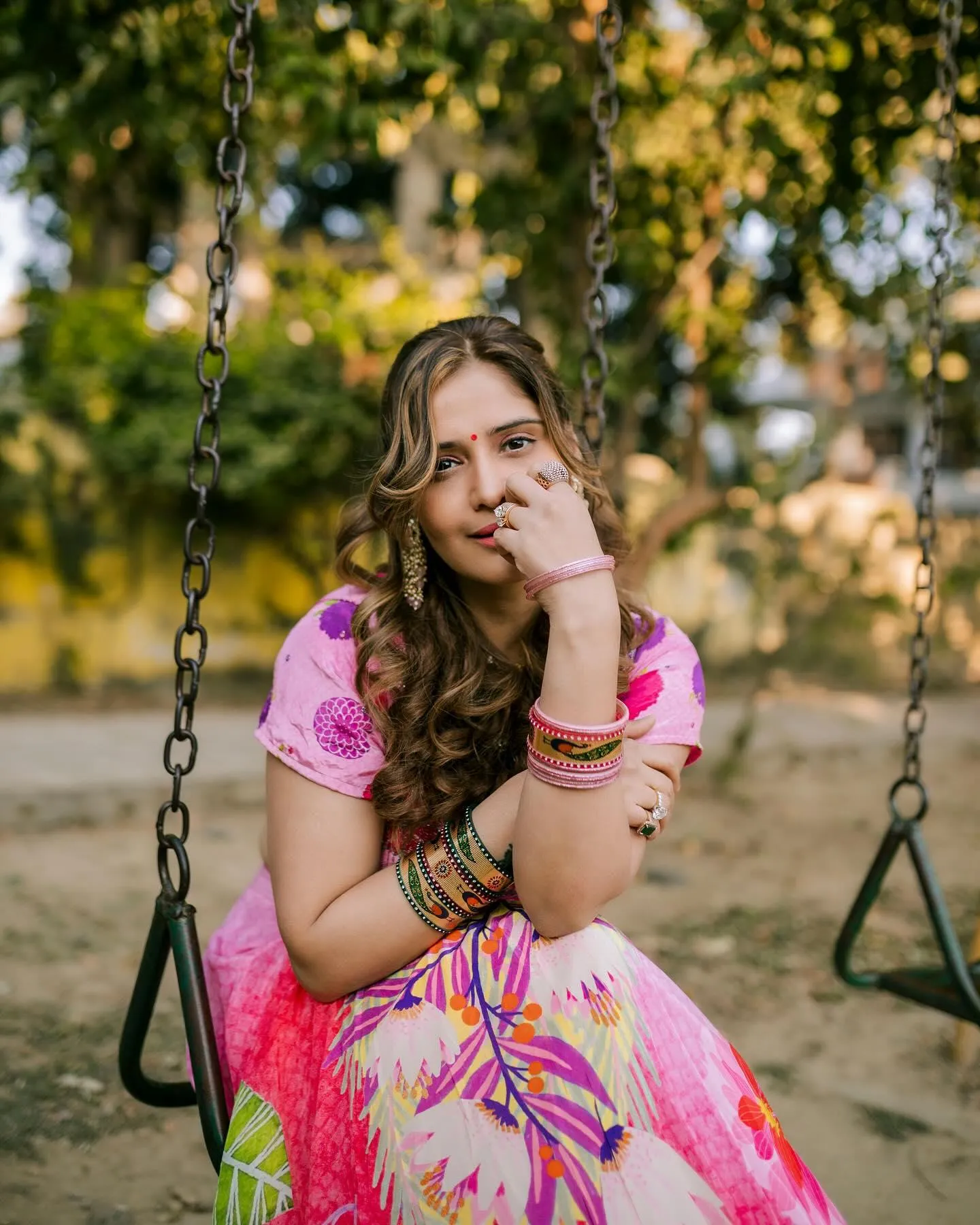 Arti Singh smiles sweetly while sitting on a swing outdoors