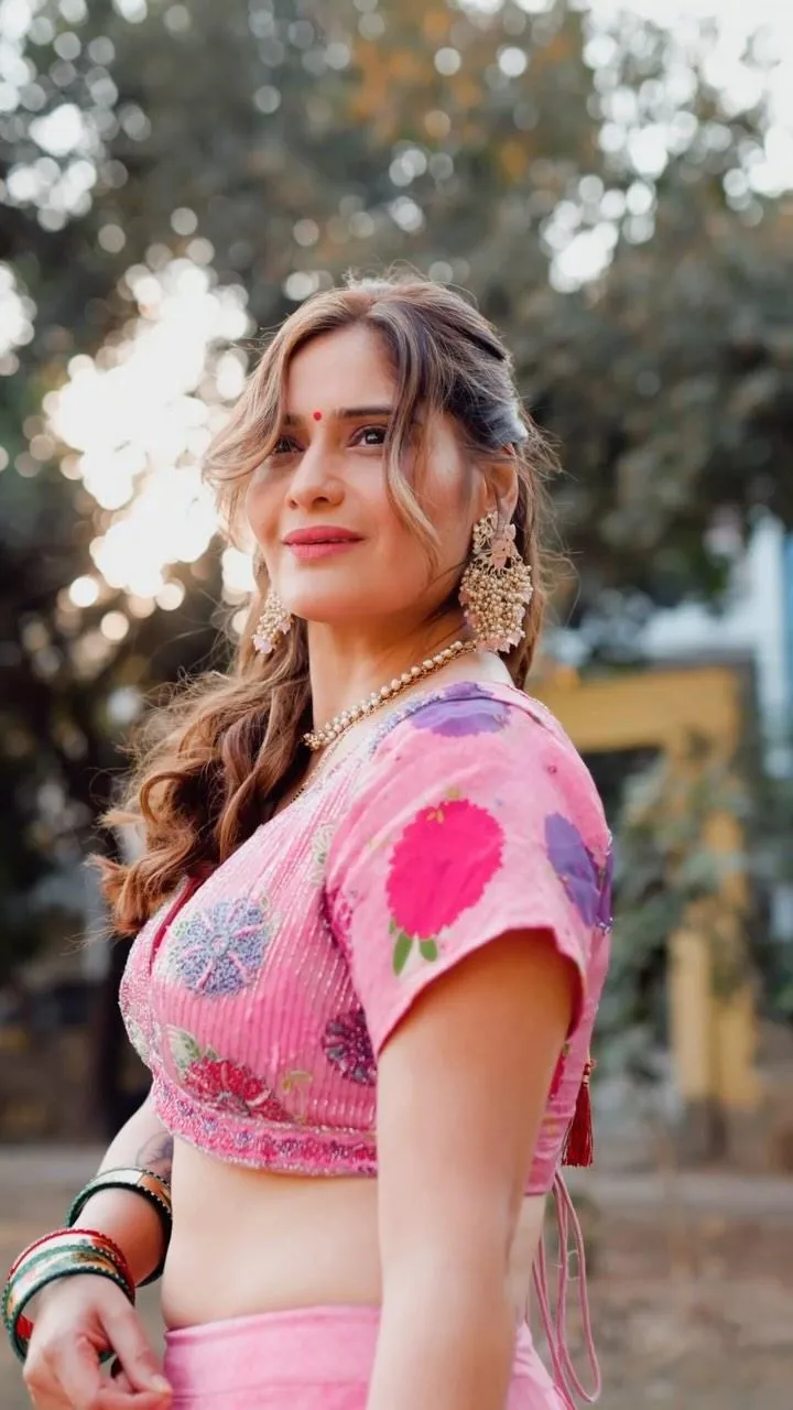 Arti Singh stands confidently in a pink blouse and lehenga