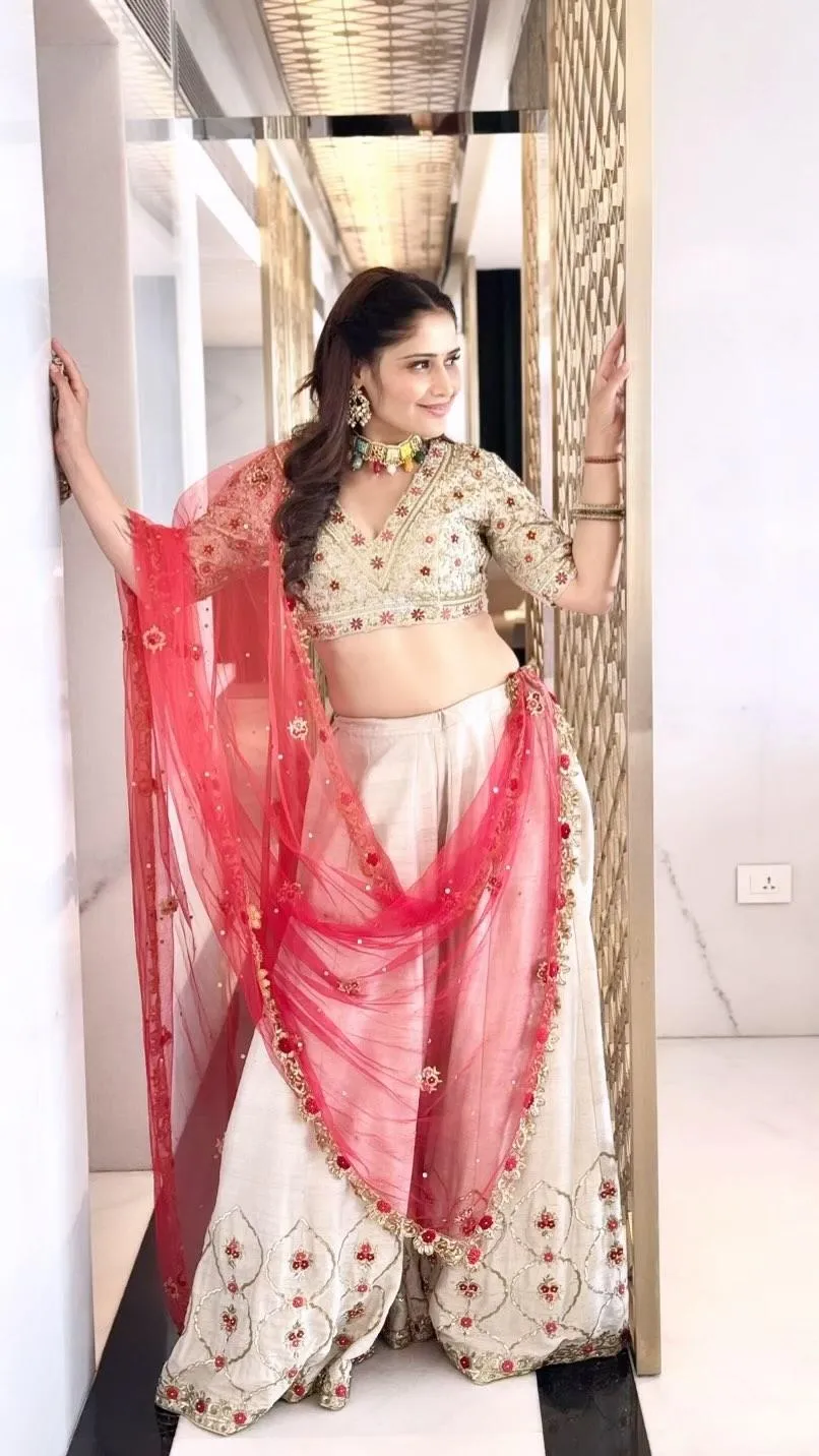Arti Singh twirls in a white lehenga with a red sheer dupatta