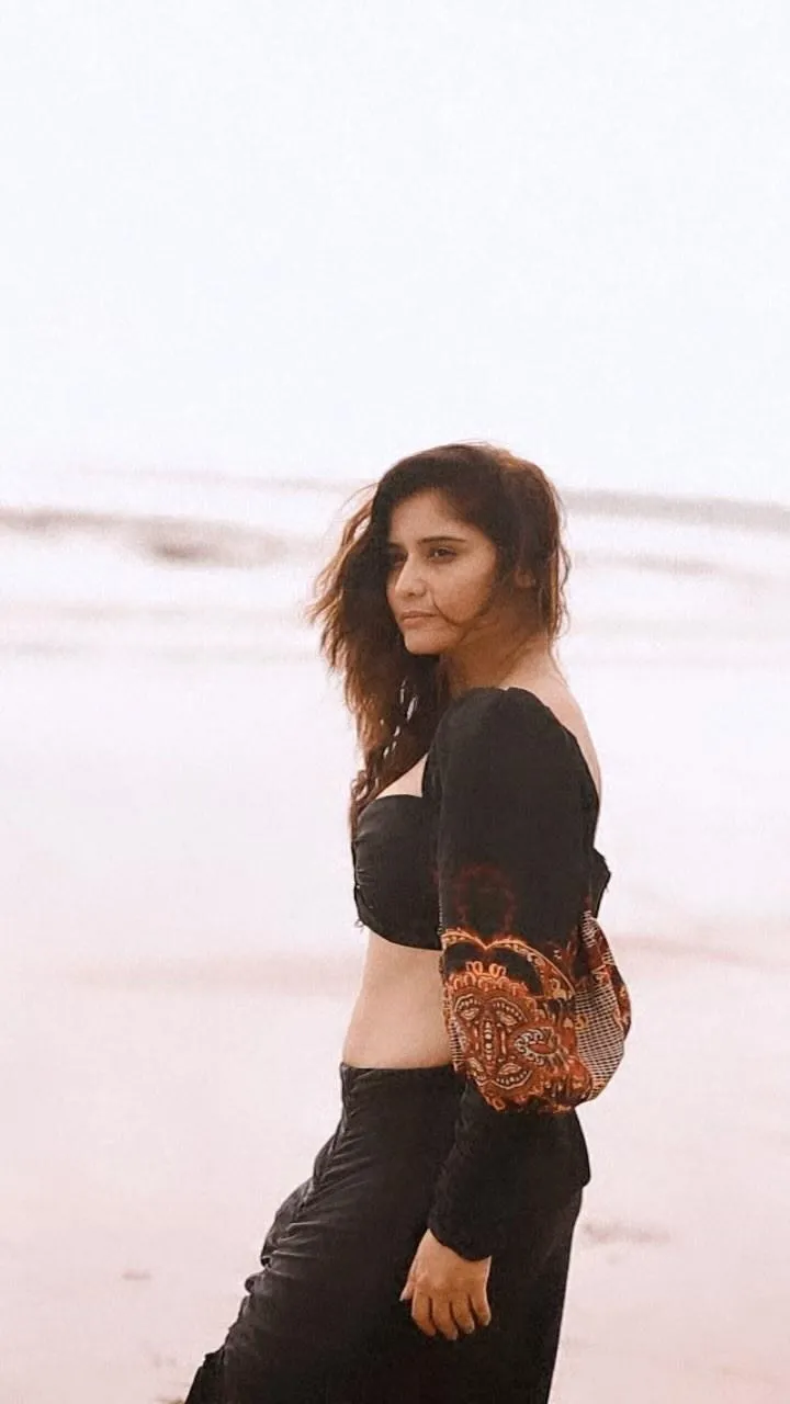Arti Singh walks on the beach in a long black skirt outfit