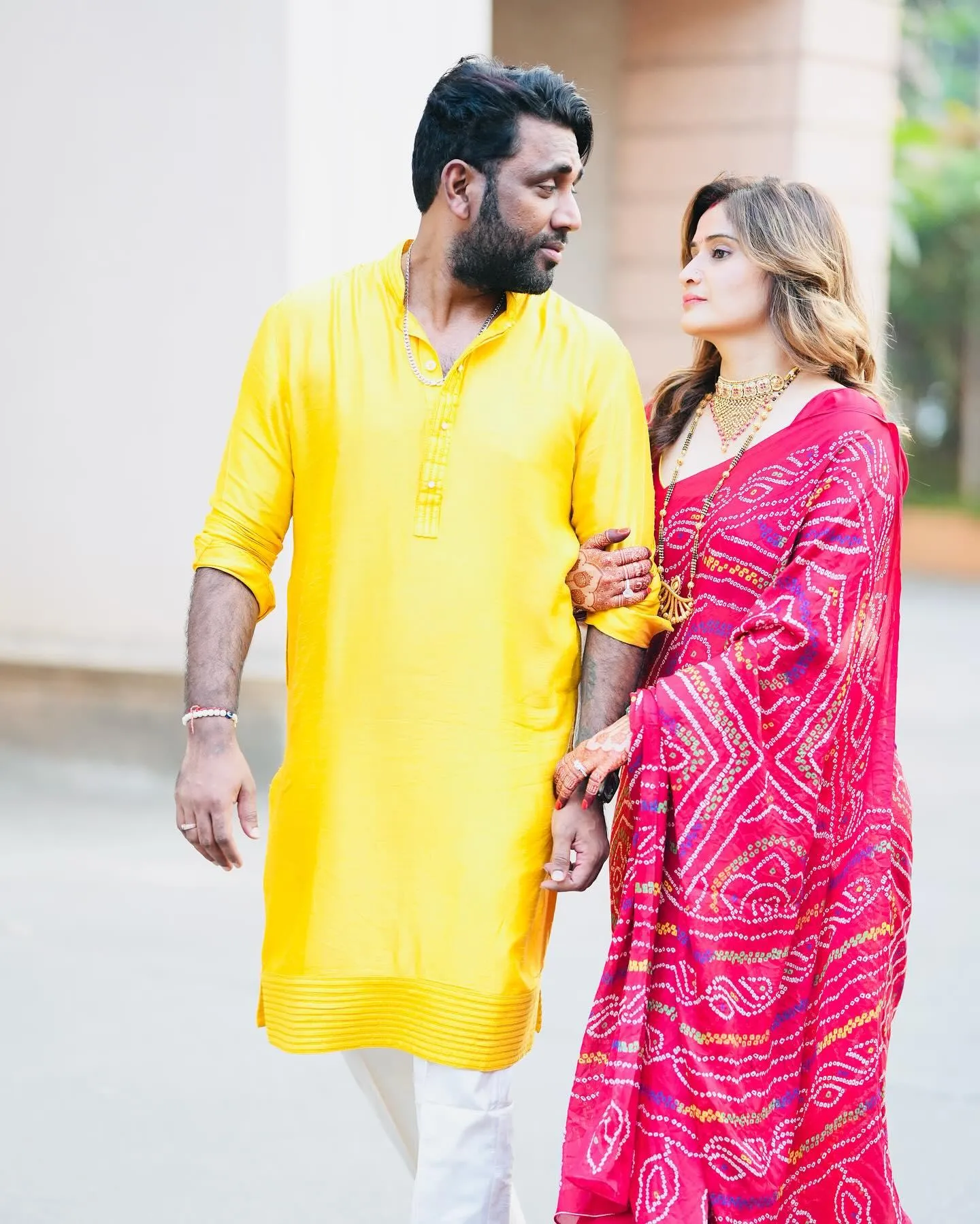 Arti Singh walks with her partner in yellow and pink outfits
