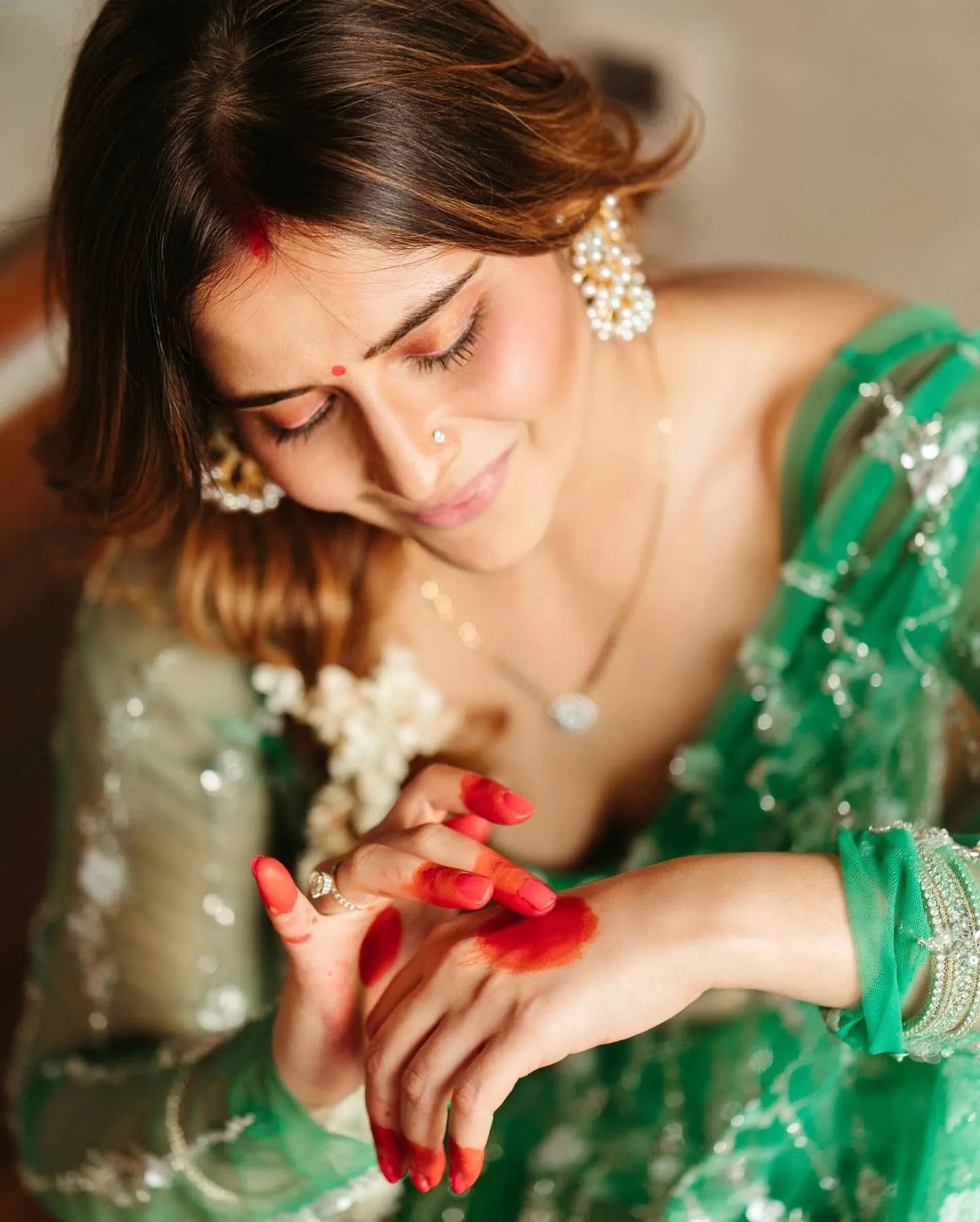 Close up of Arti Singh with folded hands in a green dress