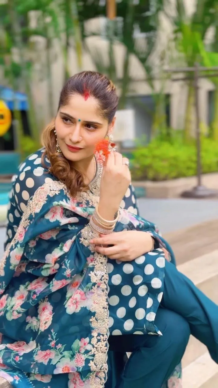 Woman sitting on a bench in a floral top with a calm pose