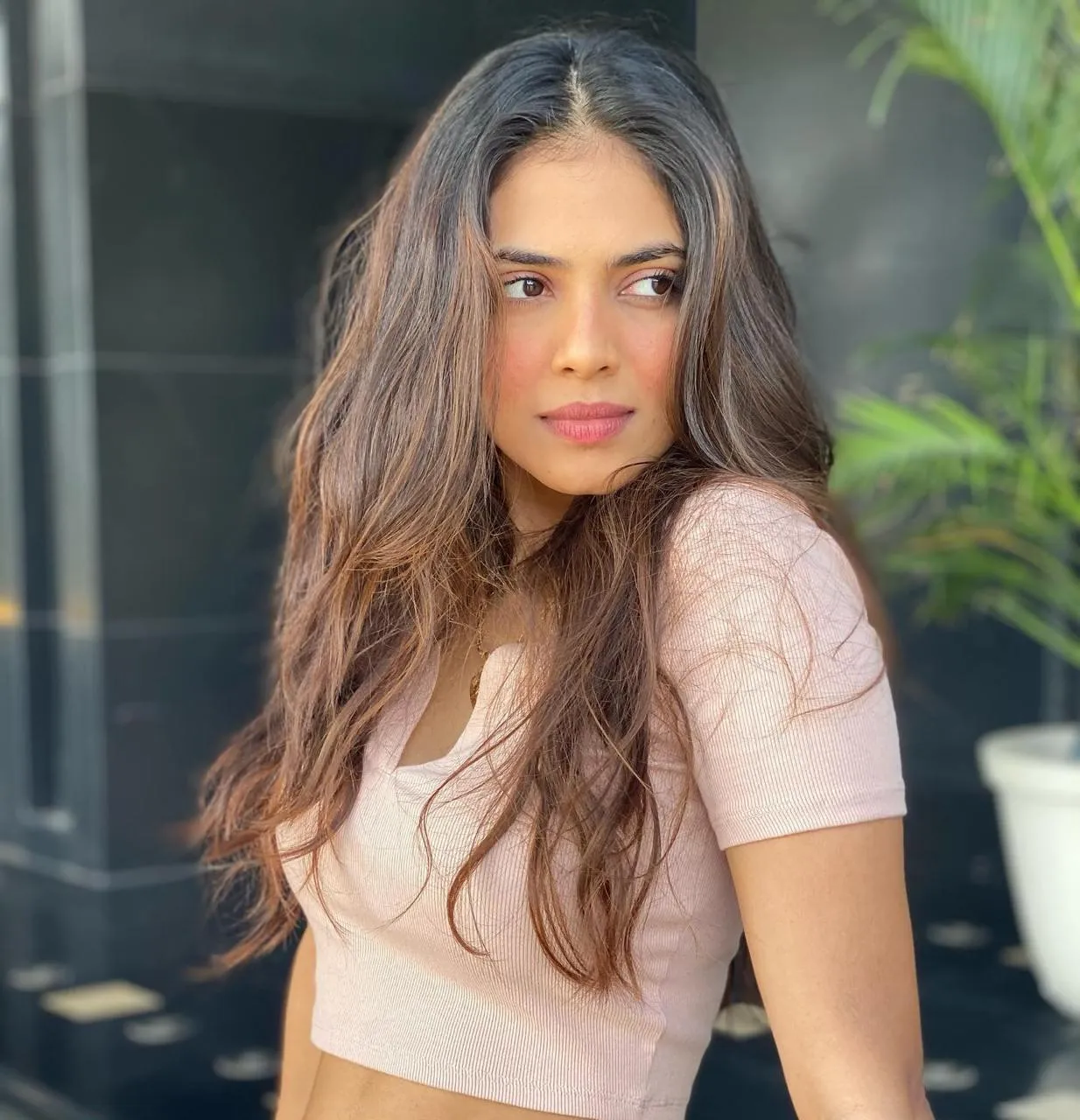 Attractive Malavika Mohanan in Light Pink Top Casual Pose