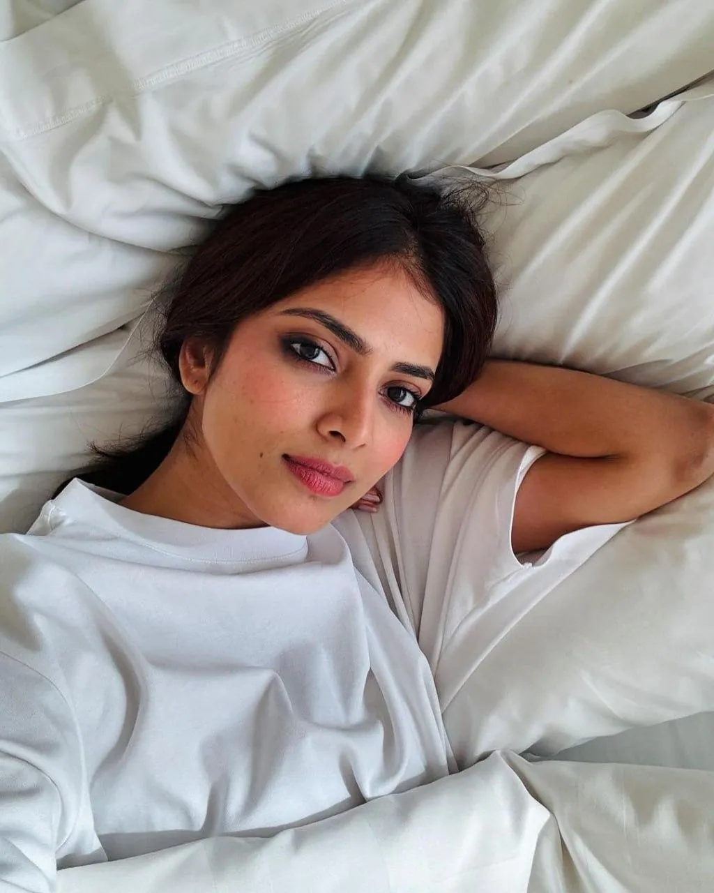 Attractive Malavika Mohanan in White Outfit Lying on Bed