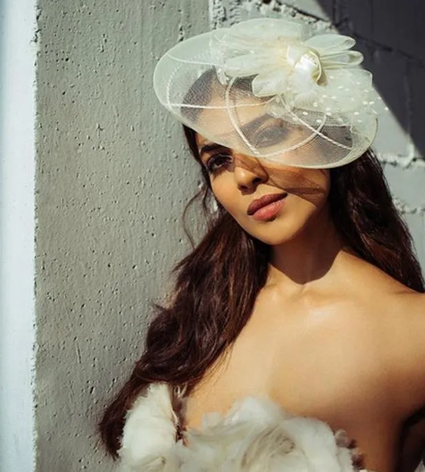 Charming Malavika Mohanan Wearing White Hat and Dress Image