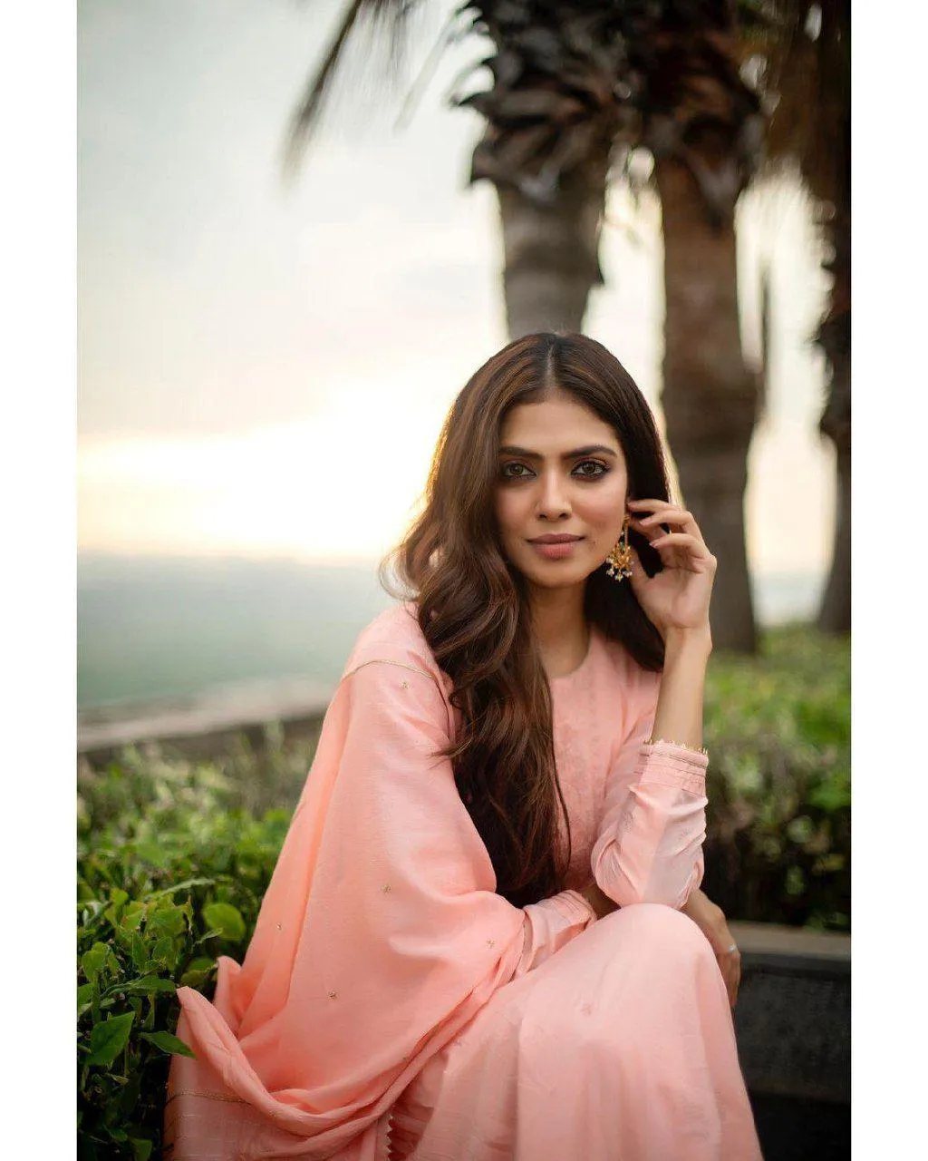Hot Malavika Mohanan in Pink Dress Outdoor Sitting Pose