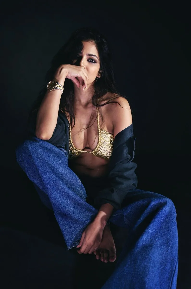 Sensual Malavika Mohanan in Blue Dress Sitting Pose Image