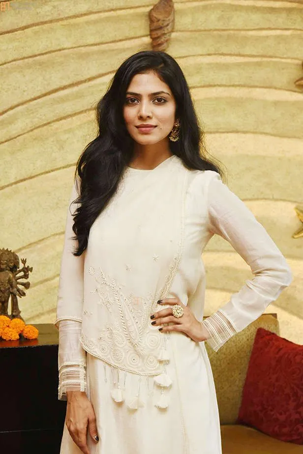 Sultry Malavika Mohanan in White Dress Standing Smiling