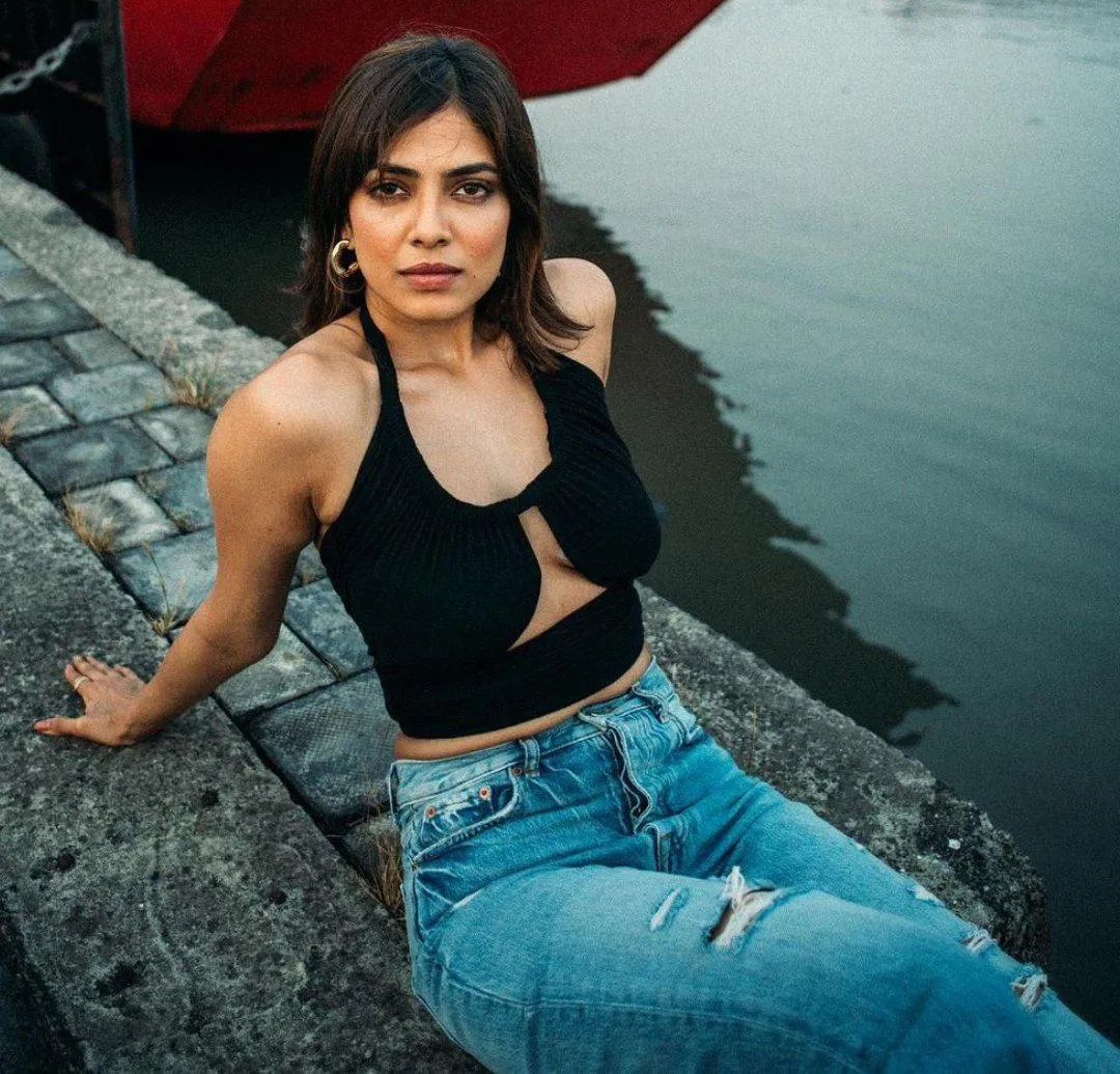 Tempting Malavika Mohanan in Black Outfit Sitting Pose
