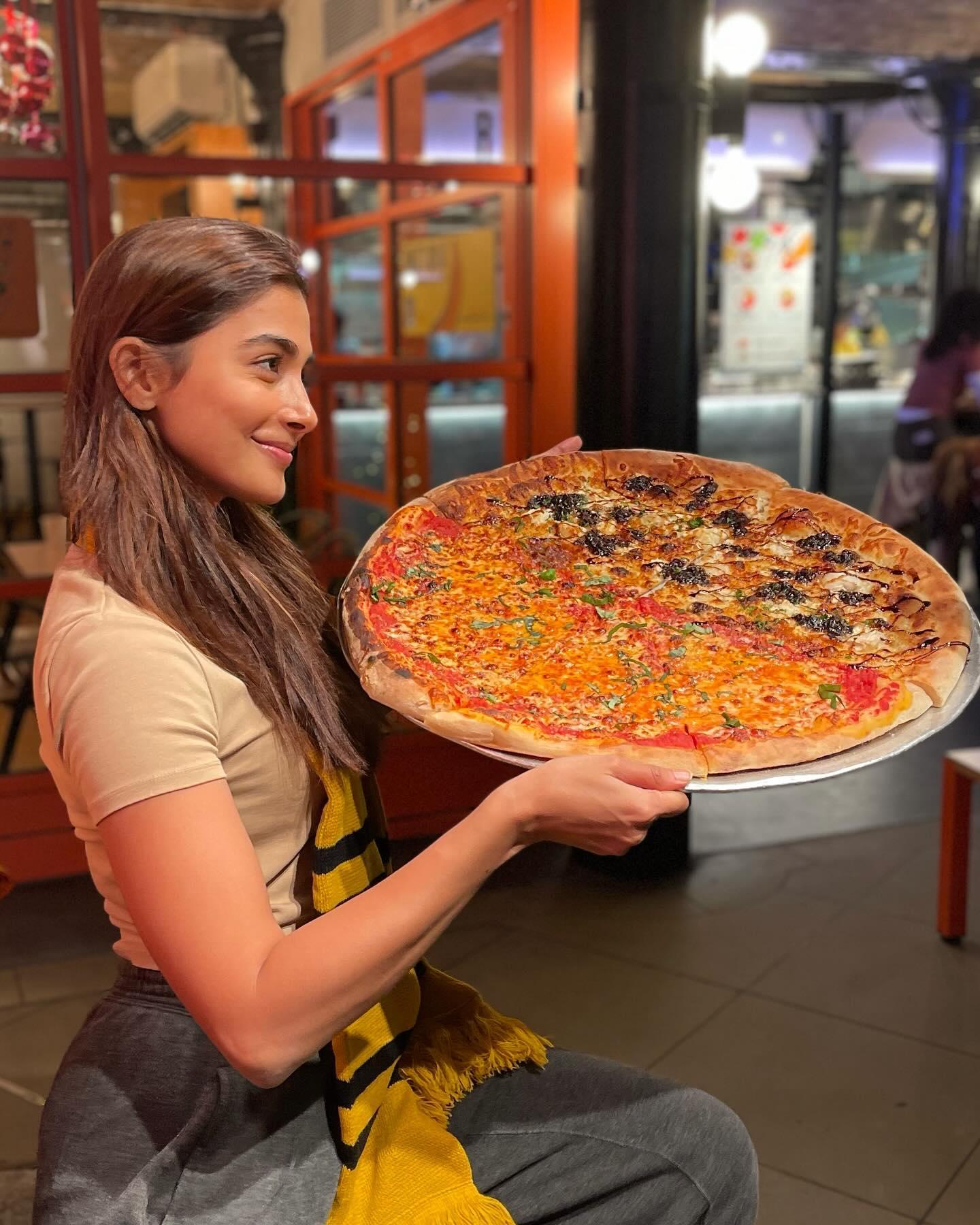Pooja Hegde Holding a Large Pizza Smiling Inside Cafe