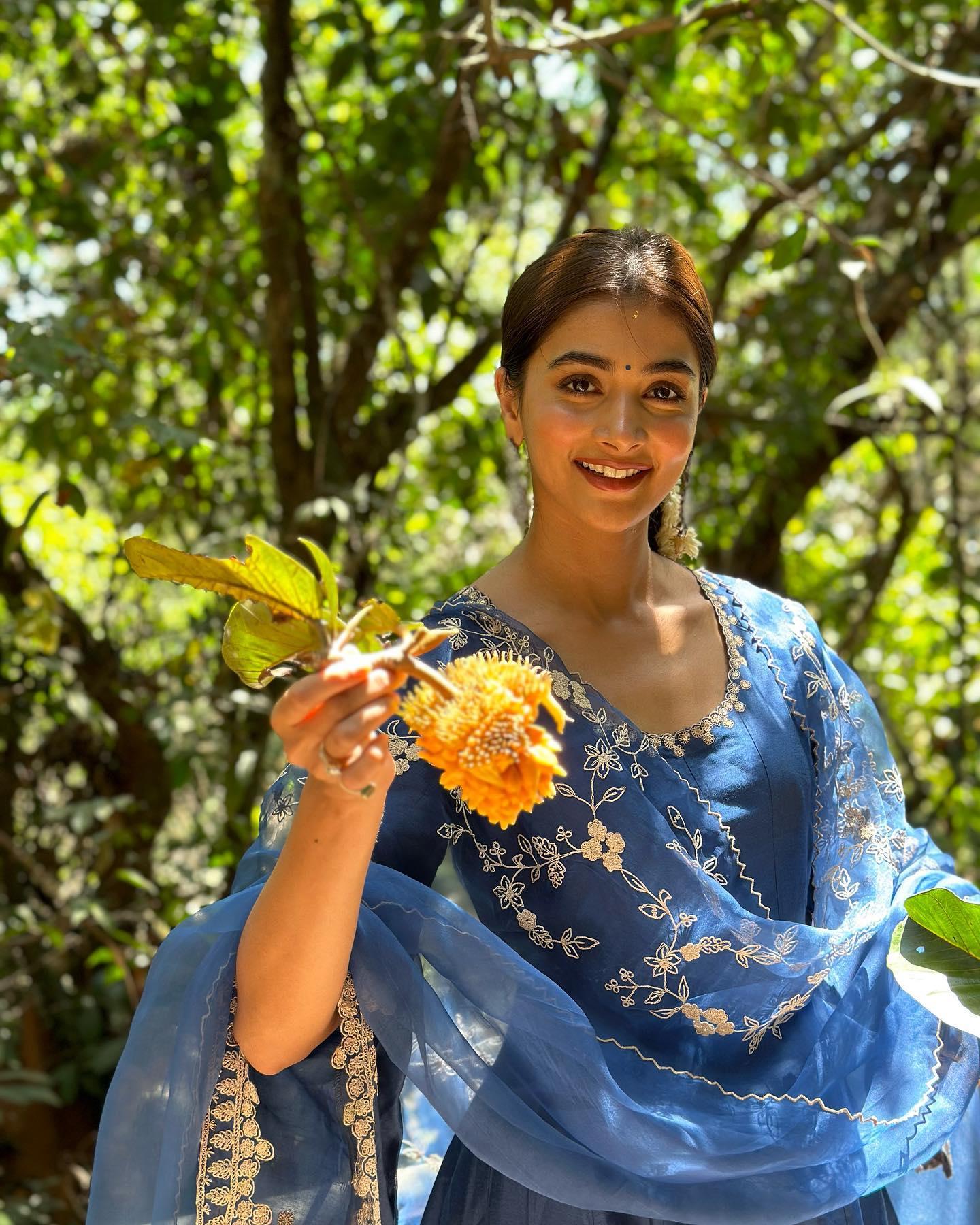 Pooja Hegde in Blue Dress Holding Flowers in Nature Image