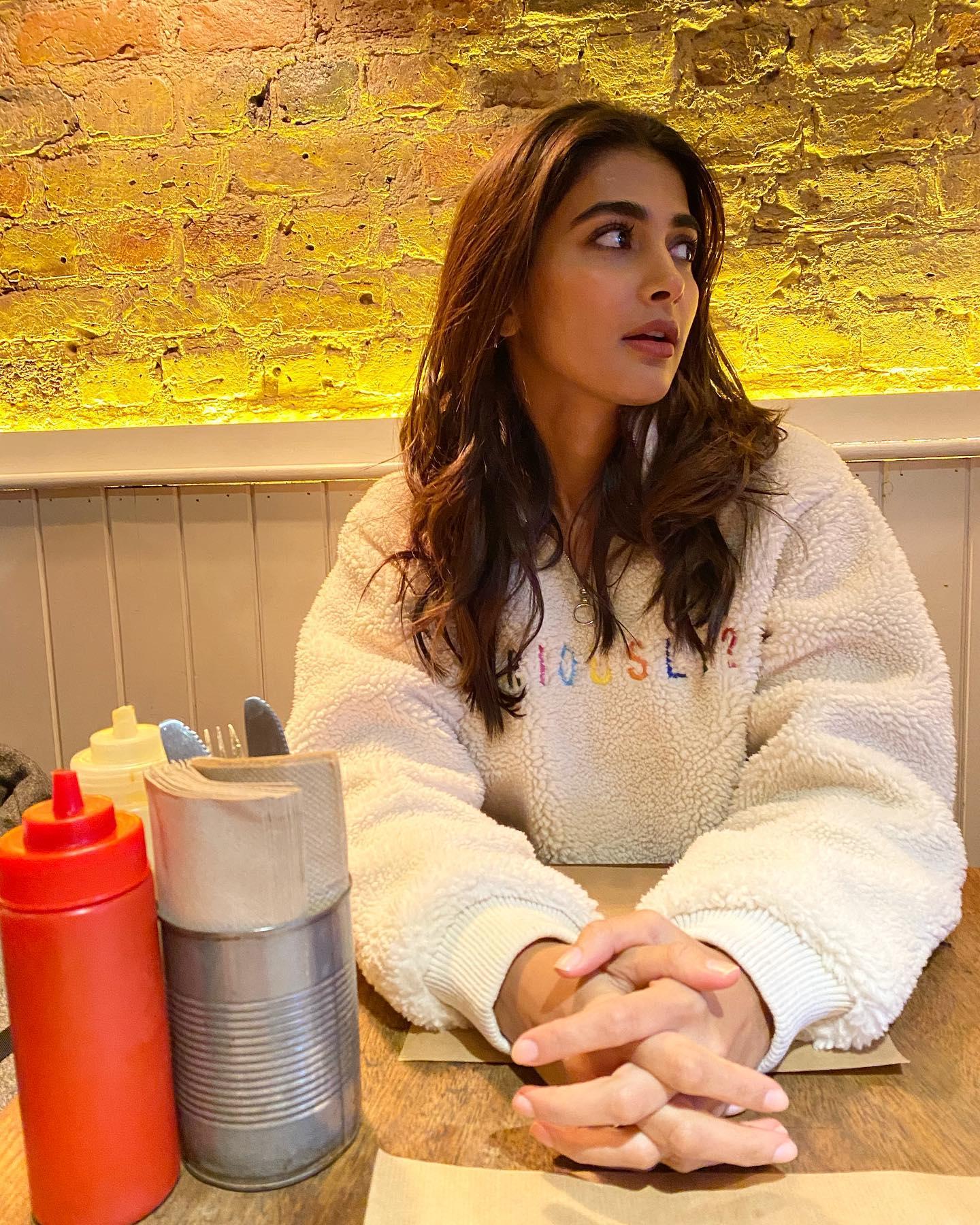 Pooja Hegde in Cozy Sweater Enjoying Warm Cafe Vibes