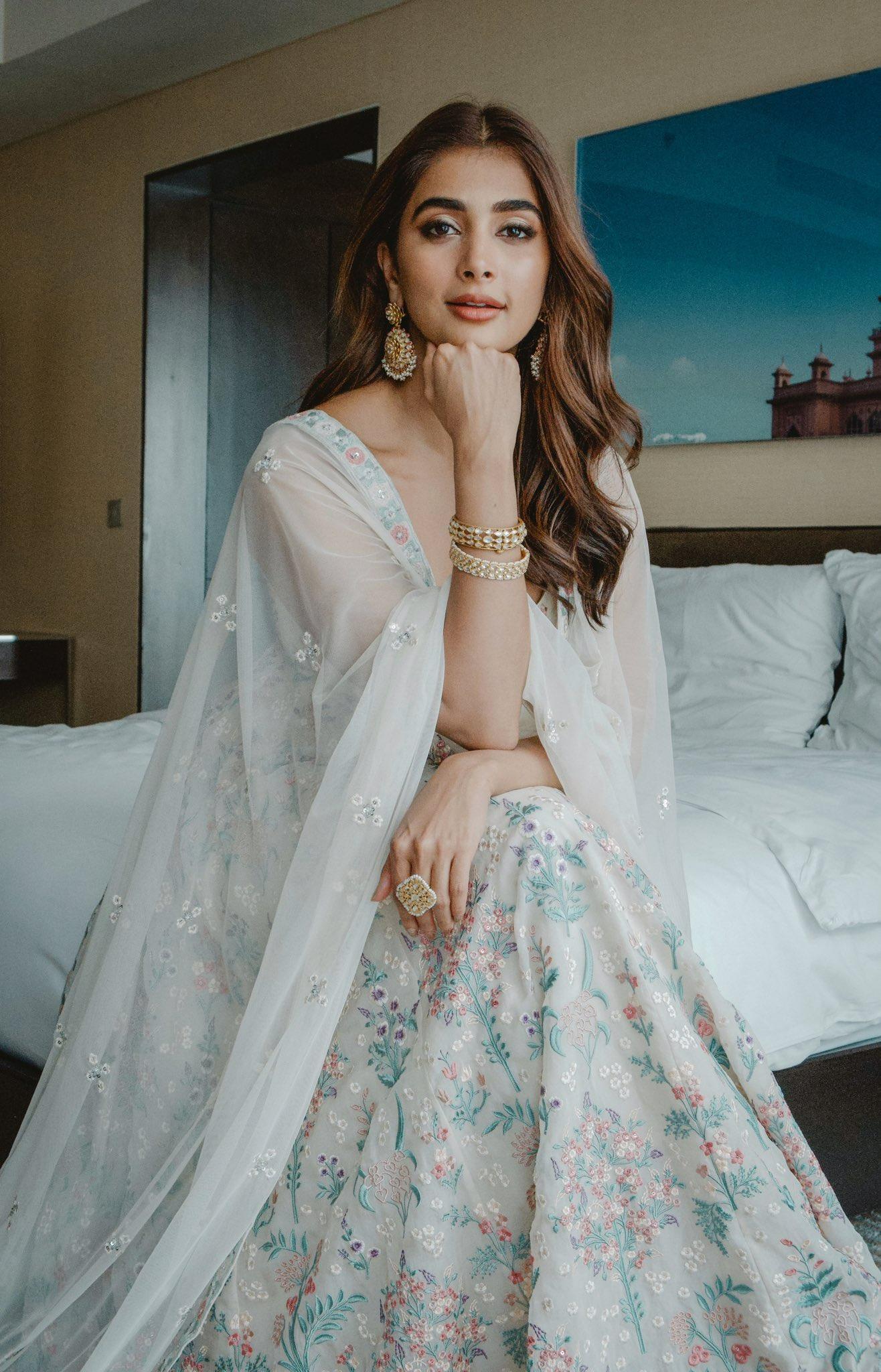 Pooja Hegde in Floral Lehenga Sitting on Hotel Bed Wallpaper