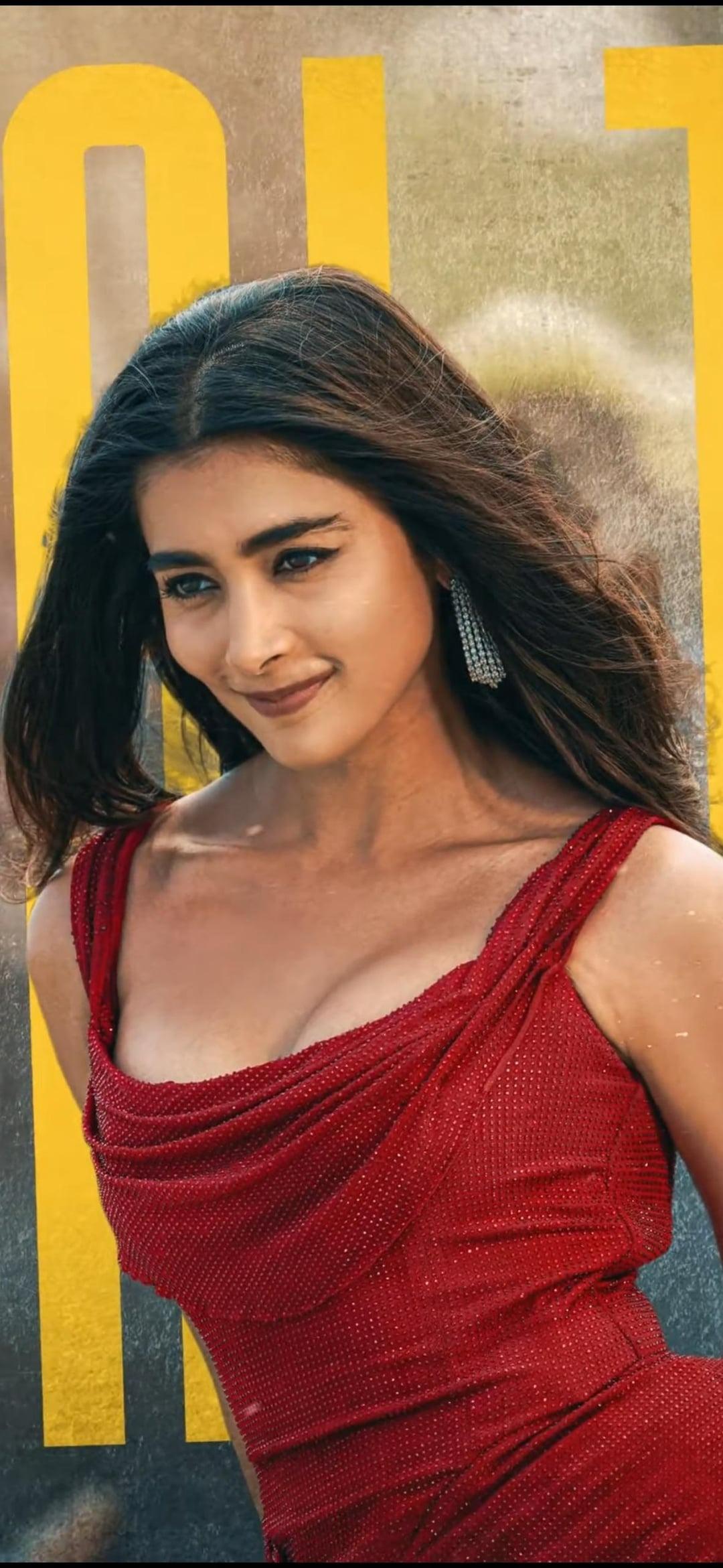 Pooja Hegde in Red Outfit Posing in Front of Yellow Poster