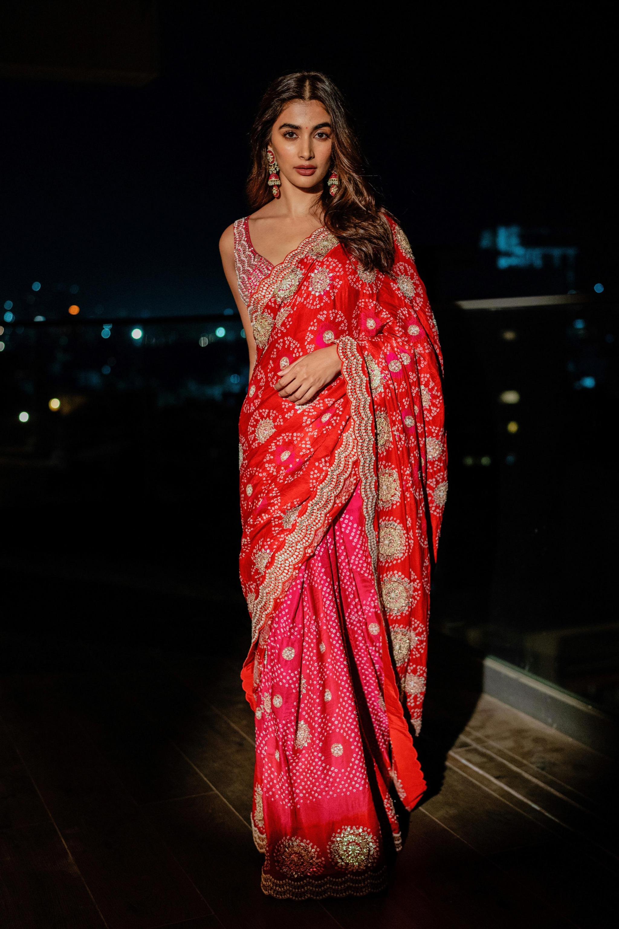 Pooja Hegde in Red Saree Posing Under City Night Lights