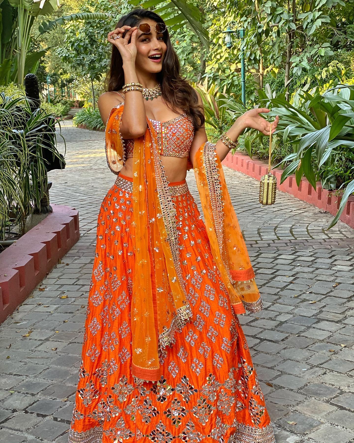Pooja Hegde in Vibrant Orange Lehenga Walking Garden Path