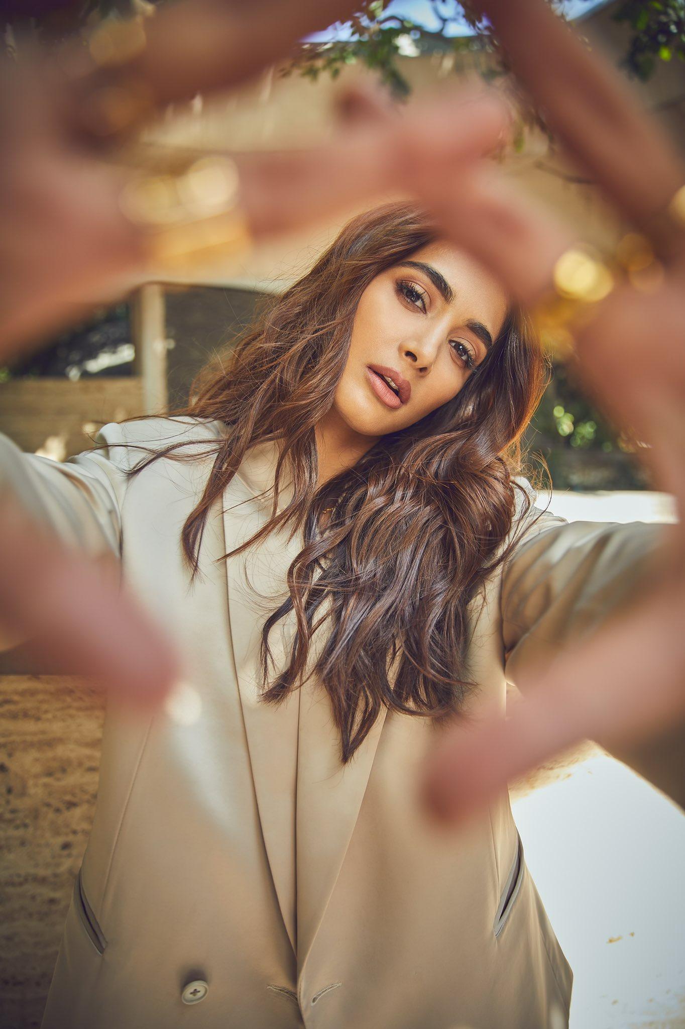 Pooja Hegde in White Coat Posing with Flowing Hair