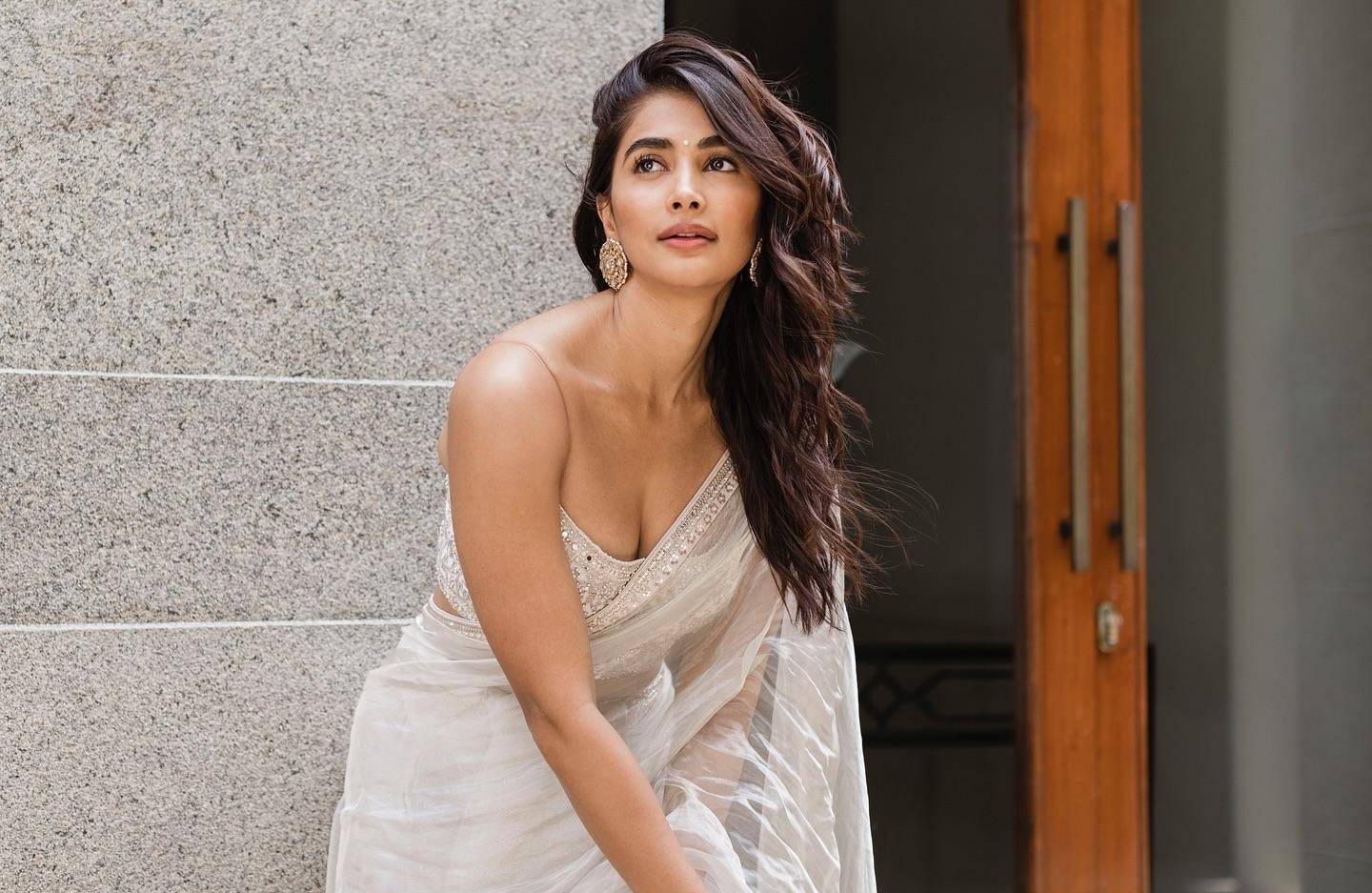 Pooja Hegde in White Saree Standing Near Modern Doorway
