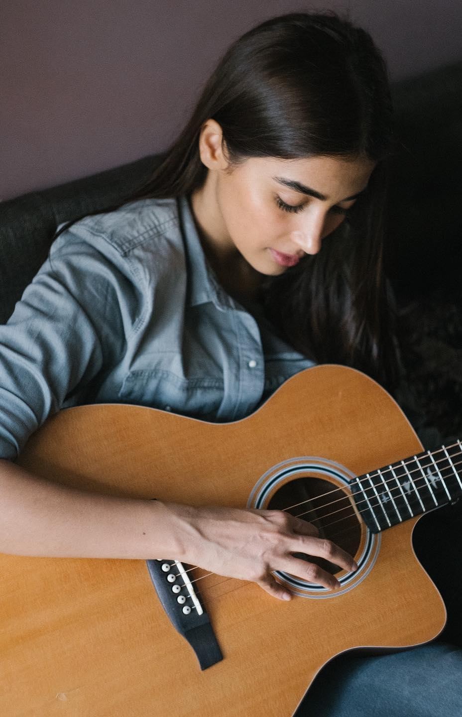 Pooja Hegde Playing Acoustic Guitar in Casual Gray Sweater