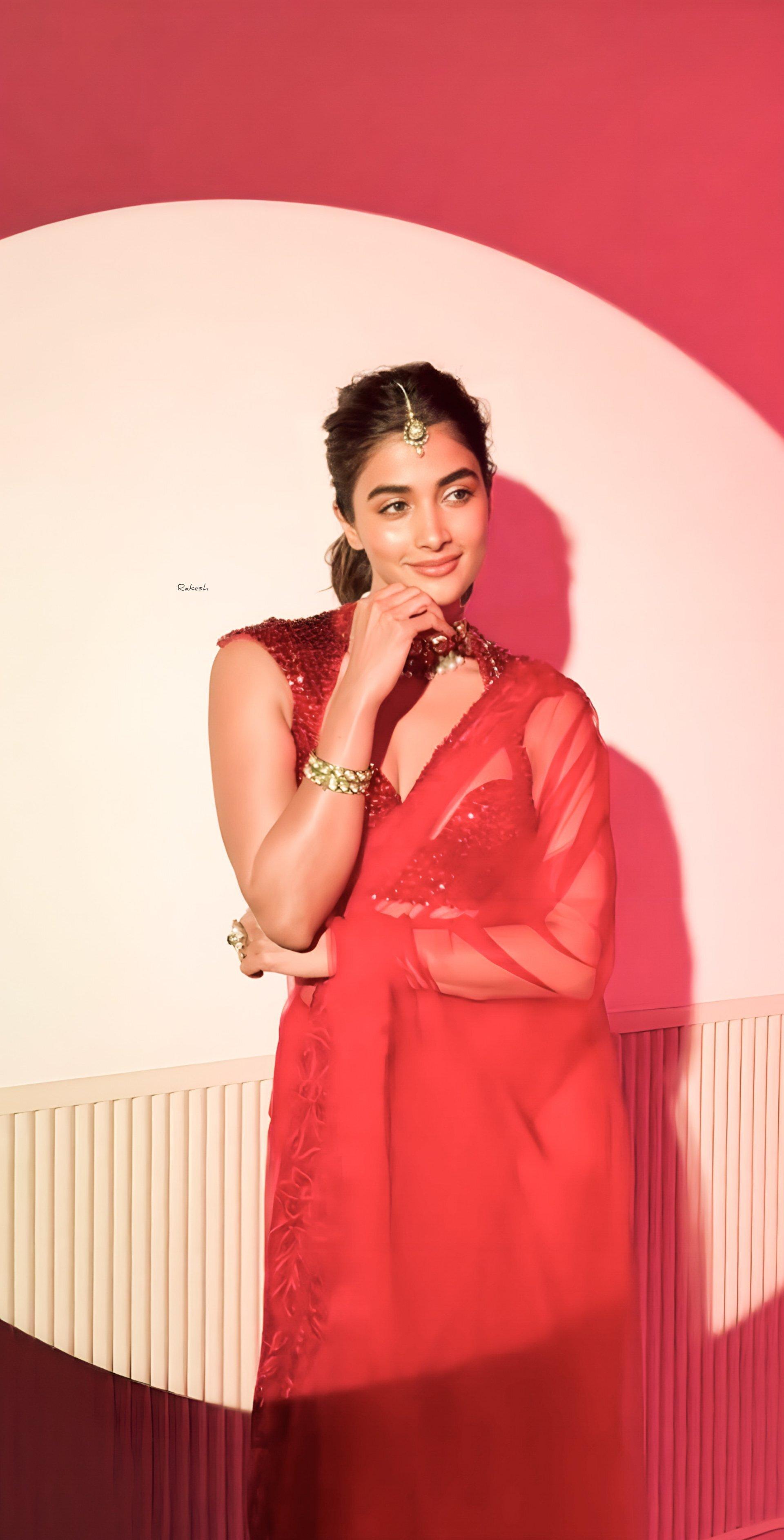 Pooja Hegde Poses in Red Saree Against Pink Background