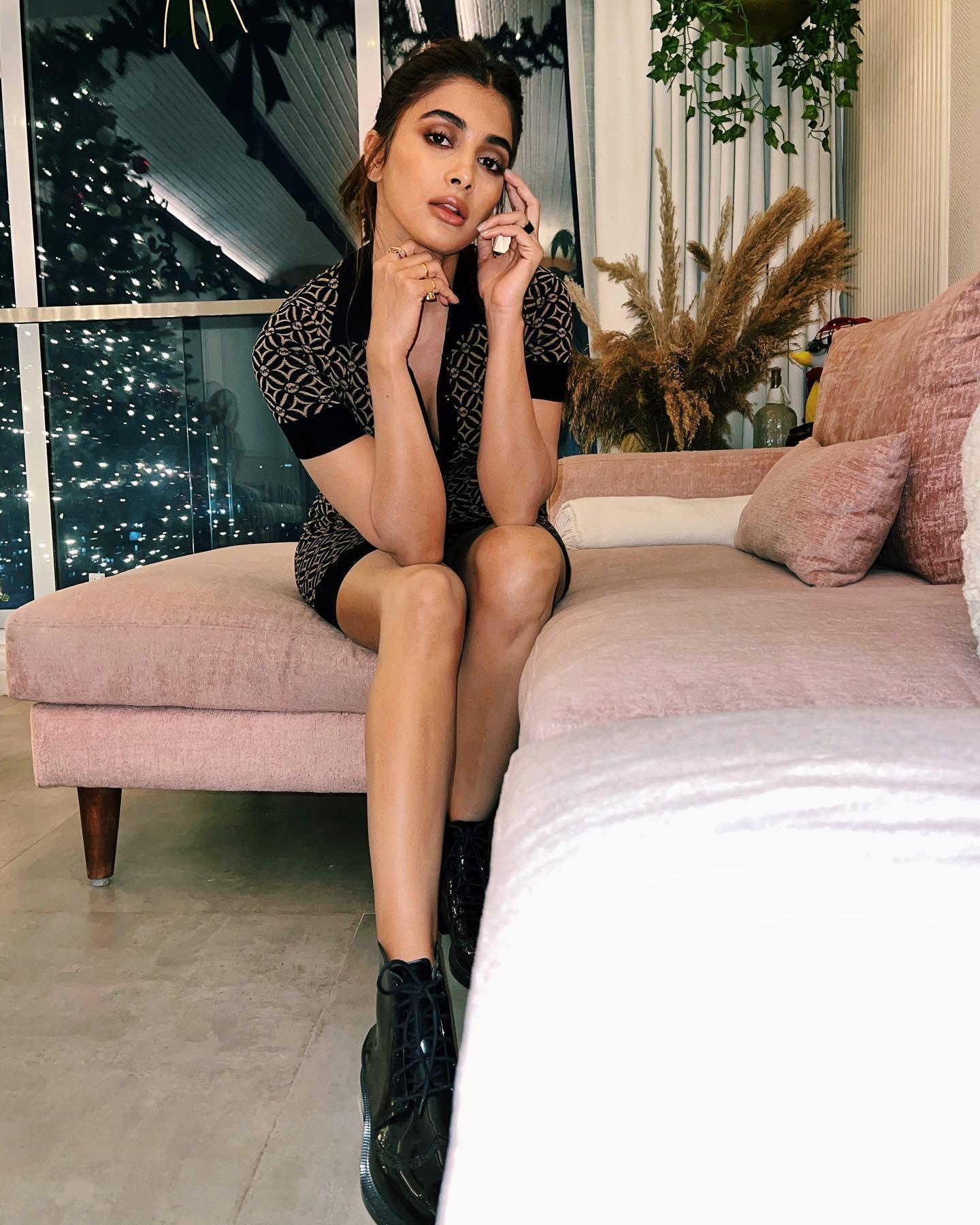 Pooja Hegde Sits in Black Outfit on Pastel Couch Wallpaper