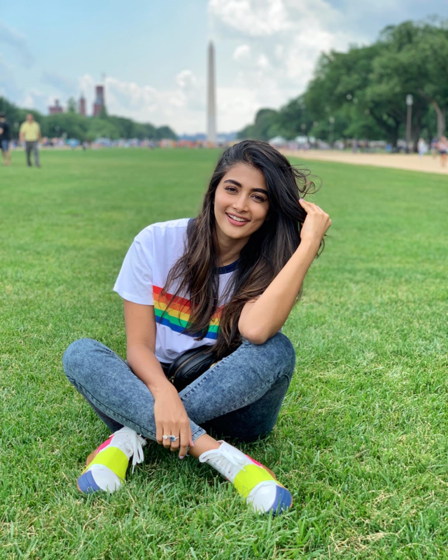 Pooja Hegde Sits on Green Grass in Casual Outfit Wallpaper