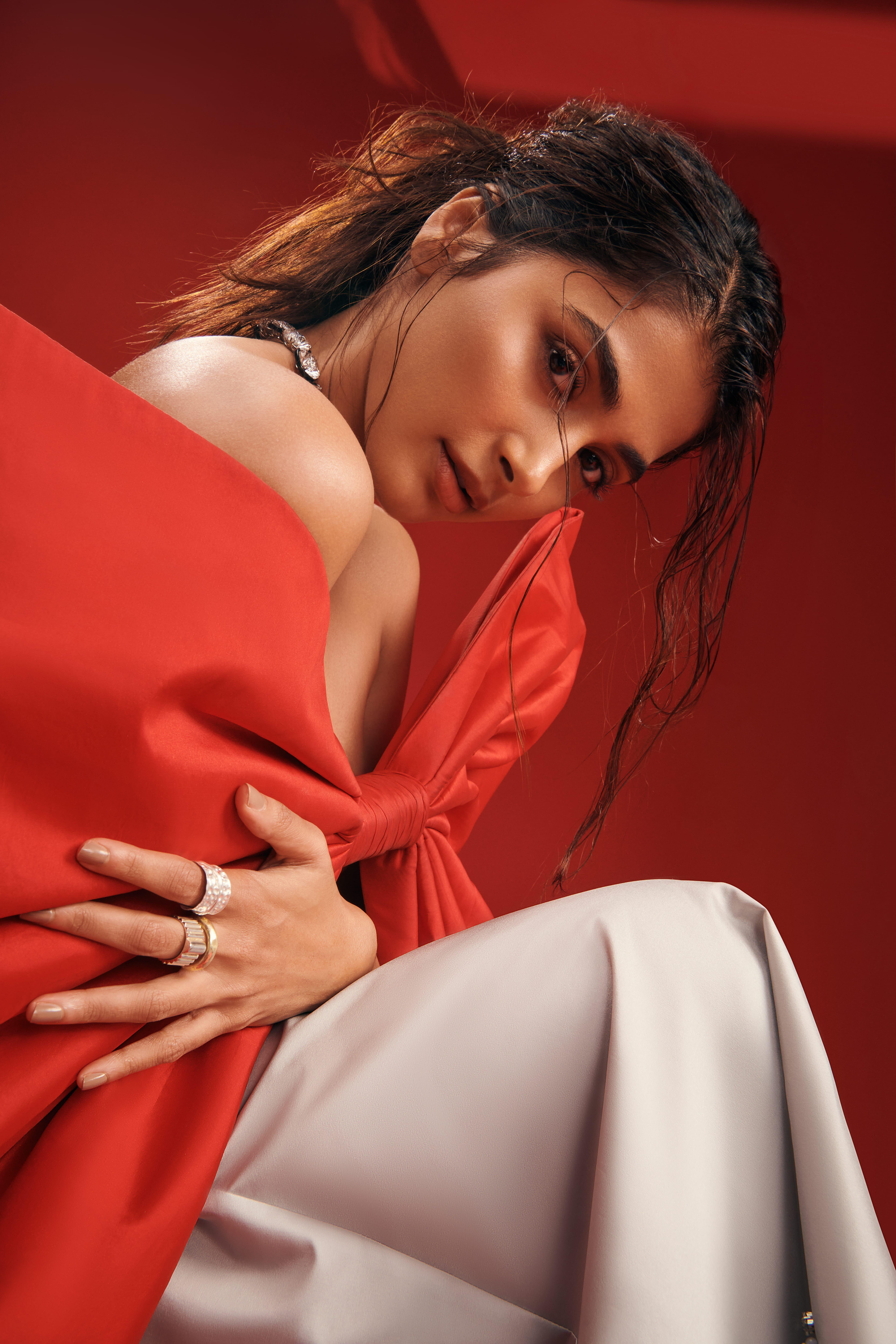 Pooja Hegde Sitting in Red Top and White Pants Elegance