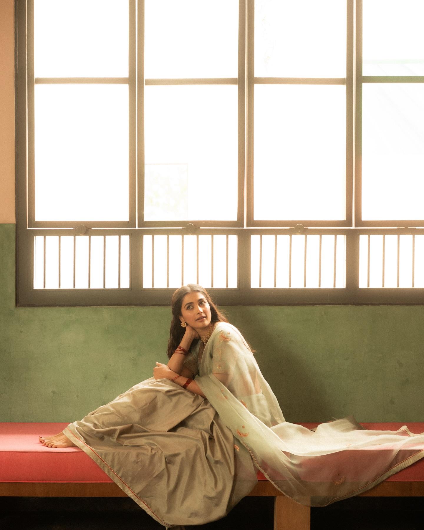 Pooja Hegde Sitting Peacefully By Window in Saree Image