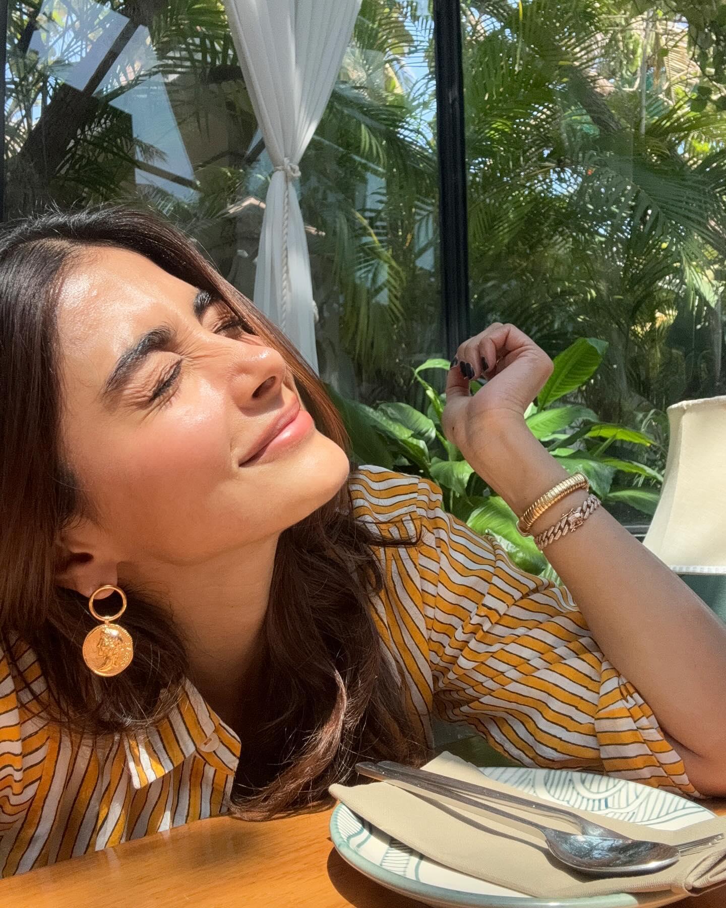 Pooja Hegde Smiling At Cafe Table with Tropical View